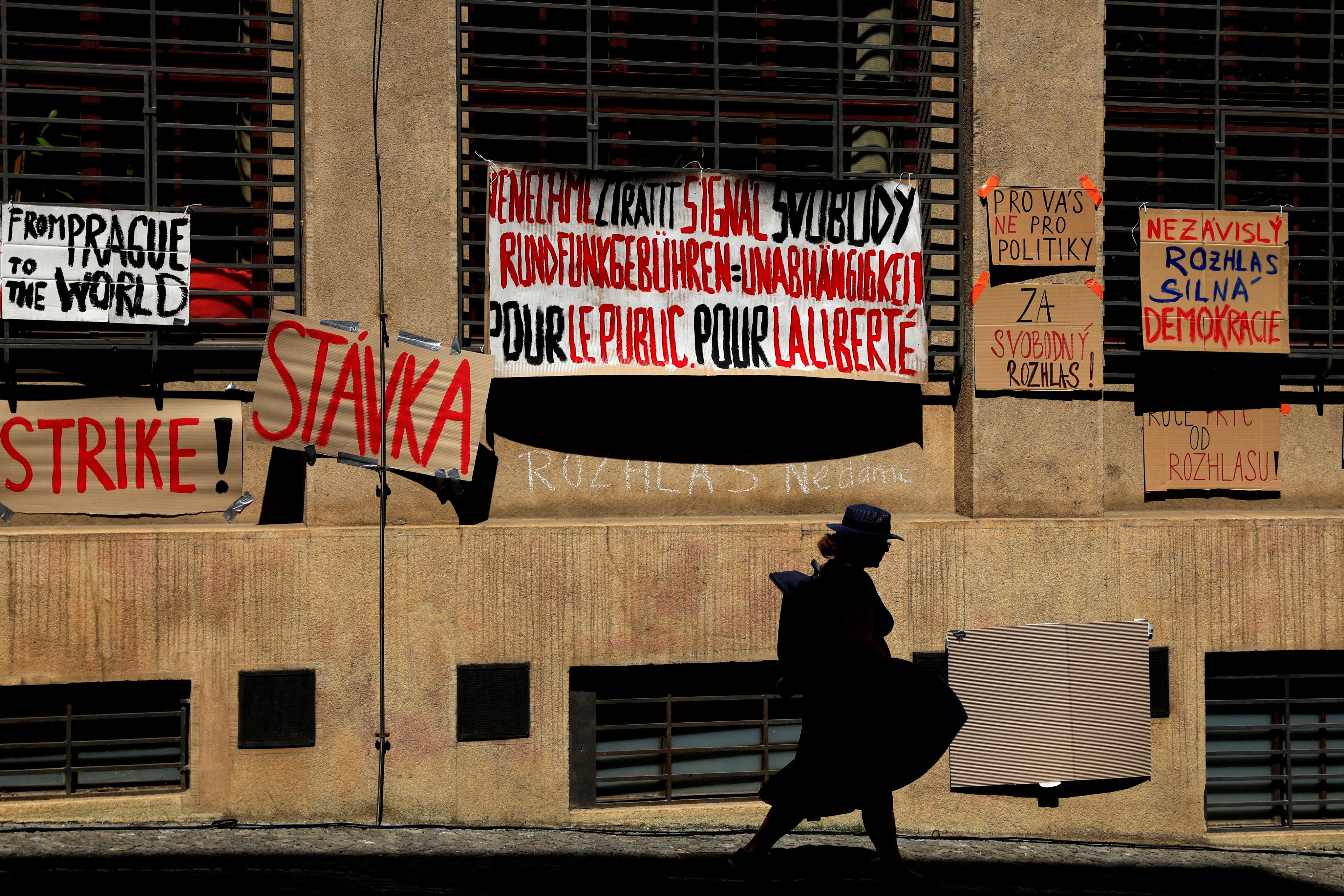 A woman walks past placards hanging on a Czech Radip building, as employees of public broadcasters strike in protest of the government’s planned overhaul of public media funding, in Prague, Czech Republic, on June 22. Photo: Reuters