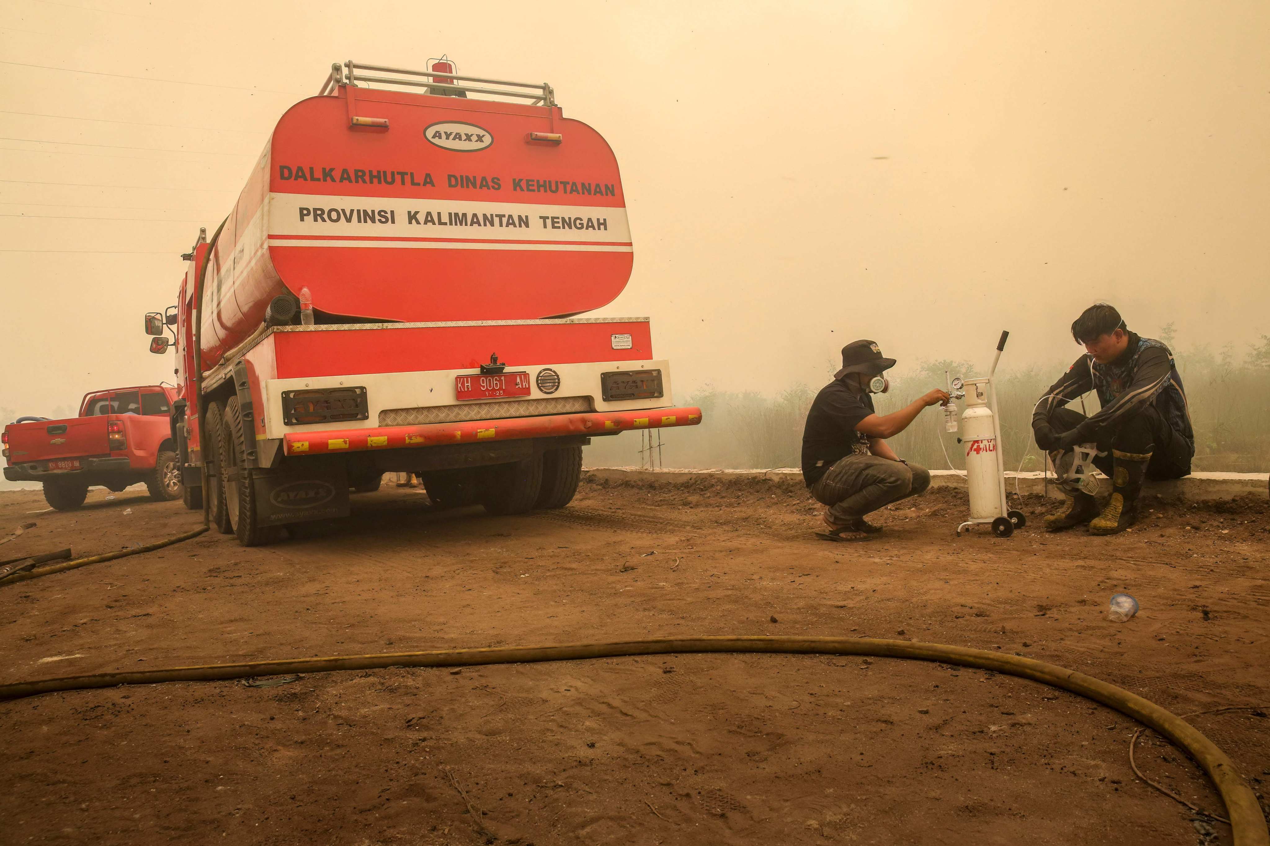 A volunteer from the Central Kalimantan Forest and Land Fire Smoke Response Coalition (RAKAT) providing mobile oxygen relief to a firefighter while battling forest and land fires in Palangkaraya, Central Kalimantan, on Thursday. Photo: AFP