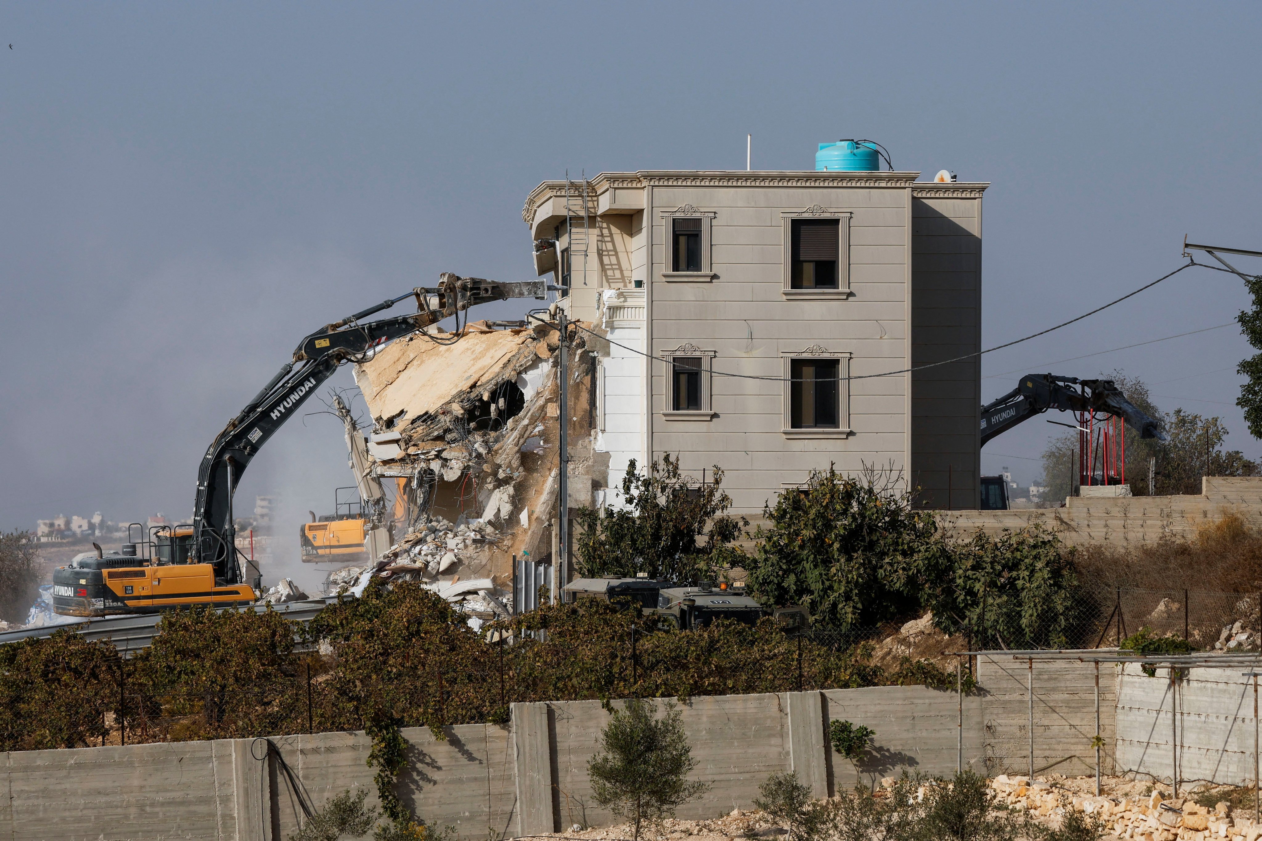 Israeli machinery demolishes a Palestinian house following a shooting attack, in Hebron in the Israeli-occupied West Bank, on Friday. Photo: Reuters