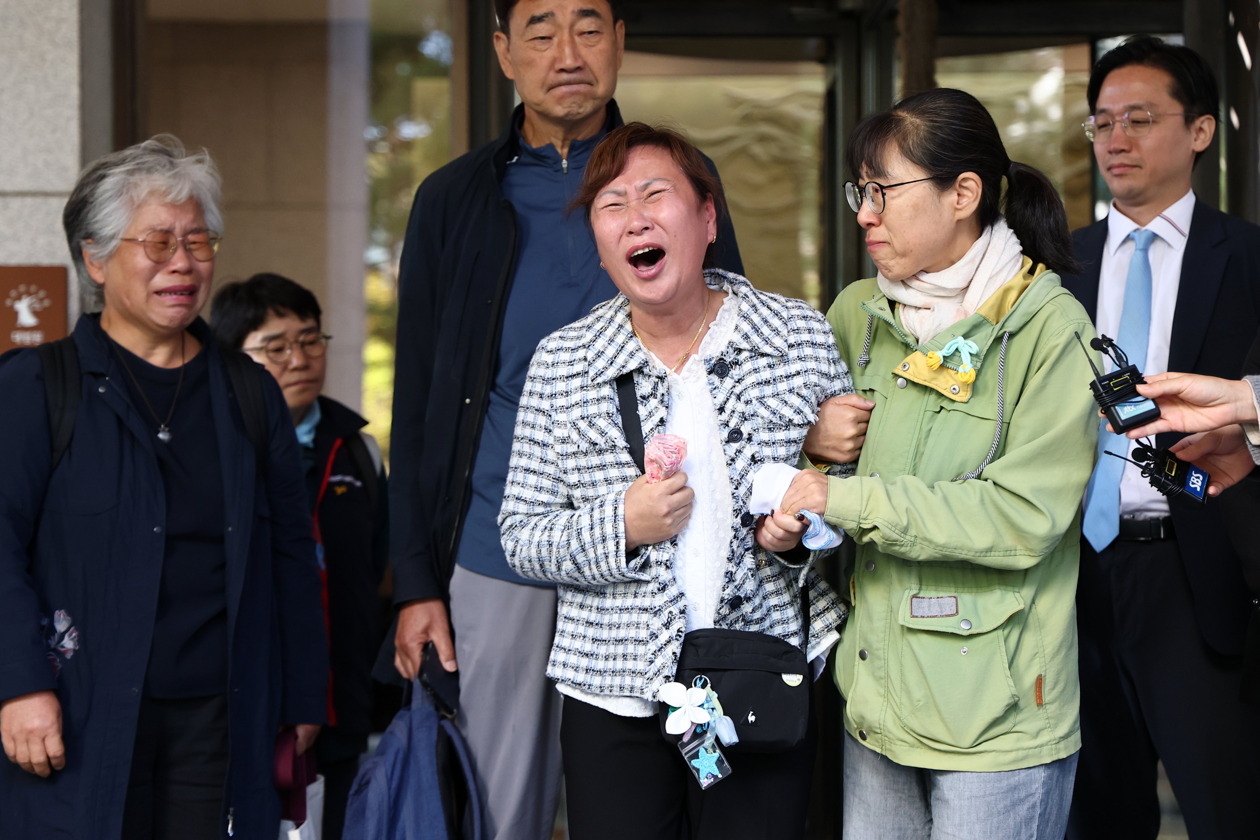 A bereaved family member weeps outside the Supreme Court in Seoul on Tuesday after it upheld a four-year jail sentence for Aricell CEO Park Soon-kwan over a fire at the company’s plant in Hwaseong in 2024 that killed 23 workers. Photo: EPA
