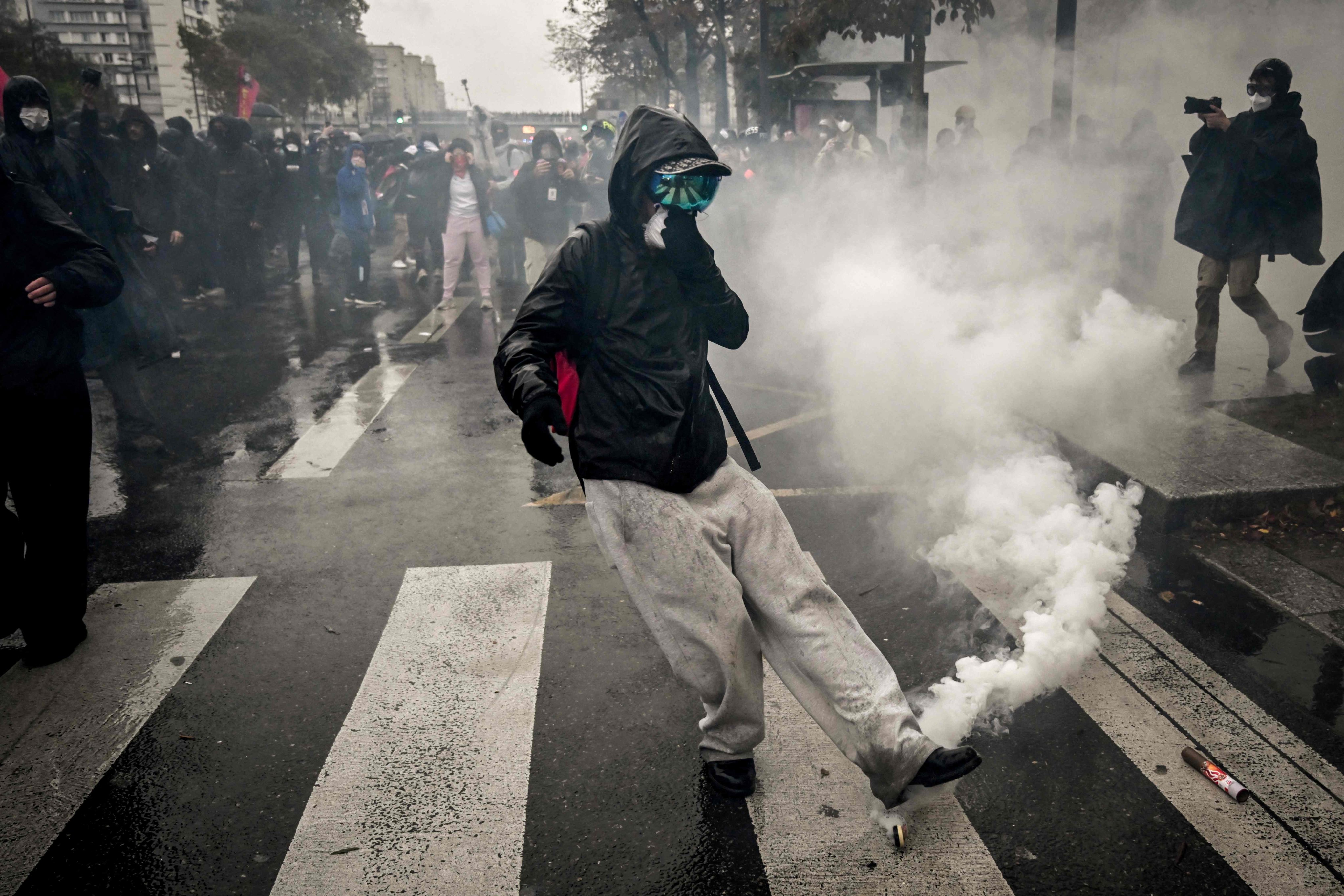 A protester kicks a tear gas canister during a demonstration in Paris on Saturday. Photo: AFP