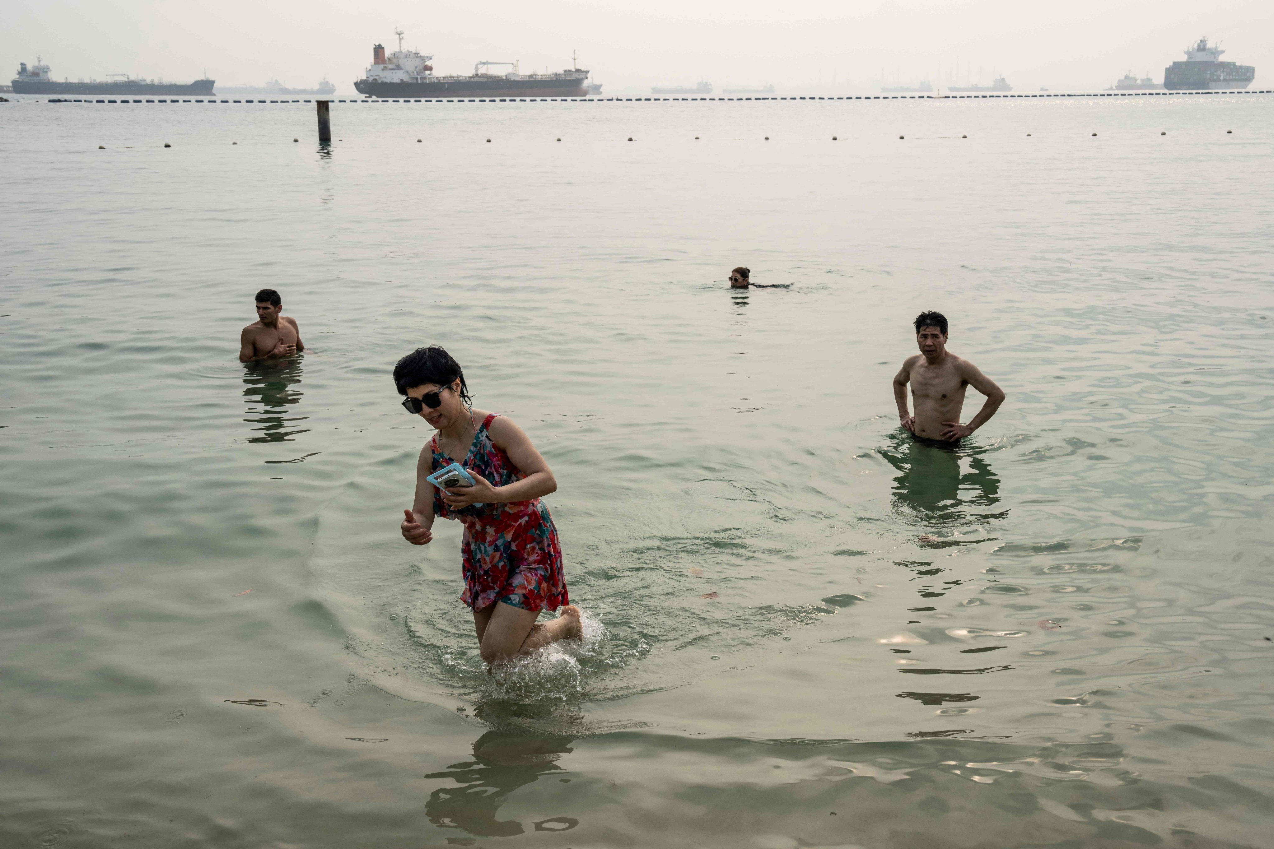 People cool off amid the haze in Siloso Beach on Singapore’s Sentosa Island on October 18. Photo: AFP