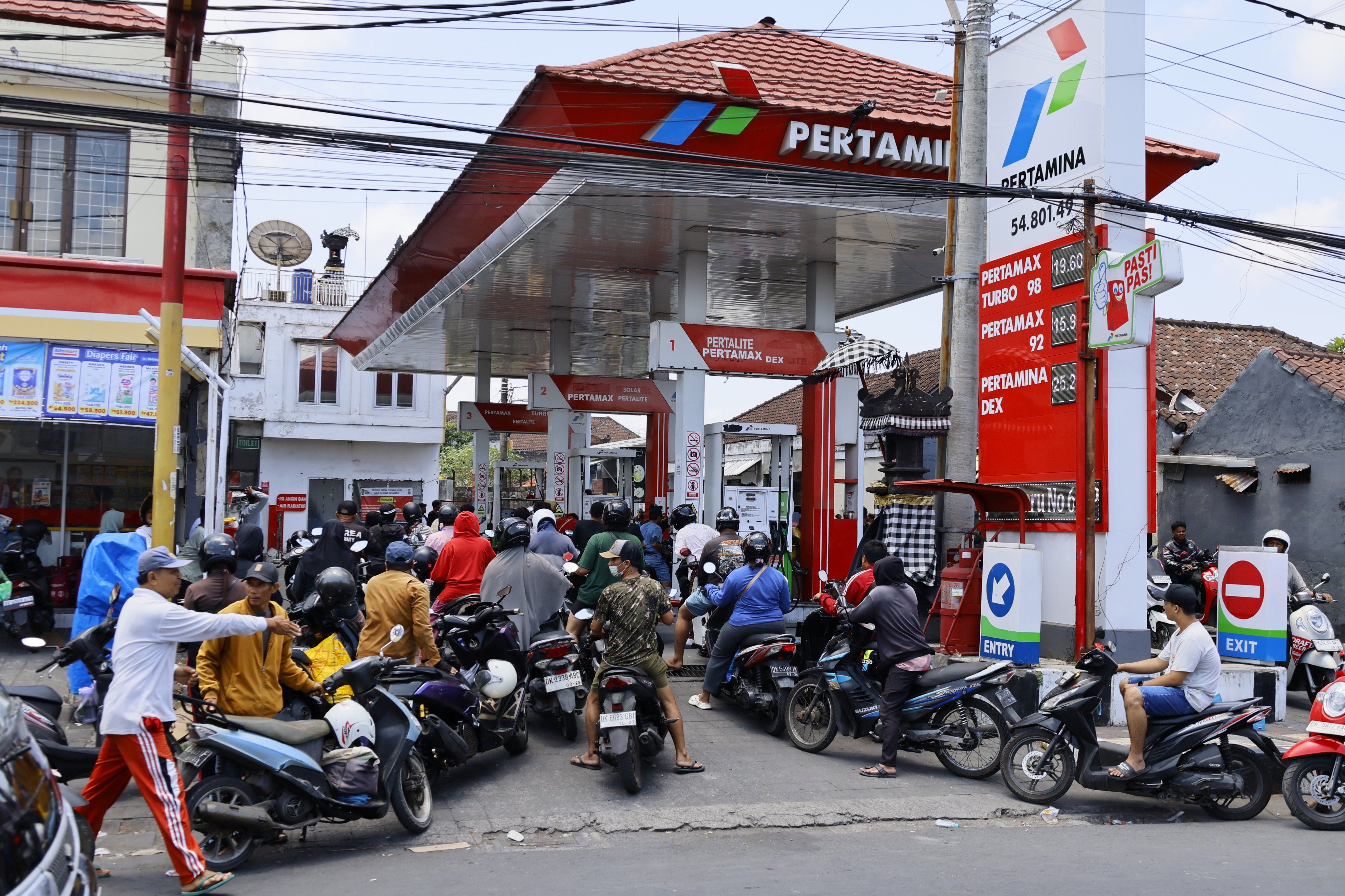Motorcyclists queue to refuel at a petrol station in Denpasar, Bali, Indonesia, on October 15. Photo:  EPA