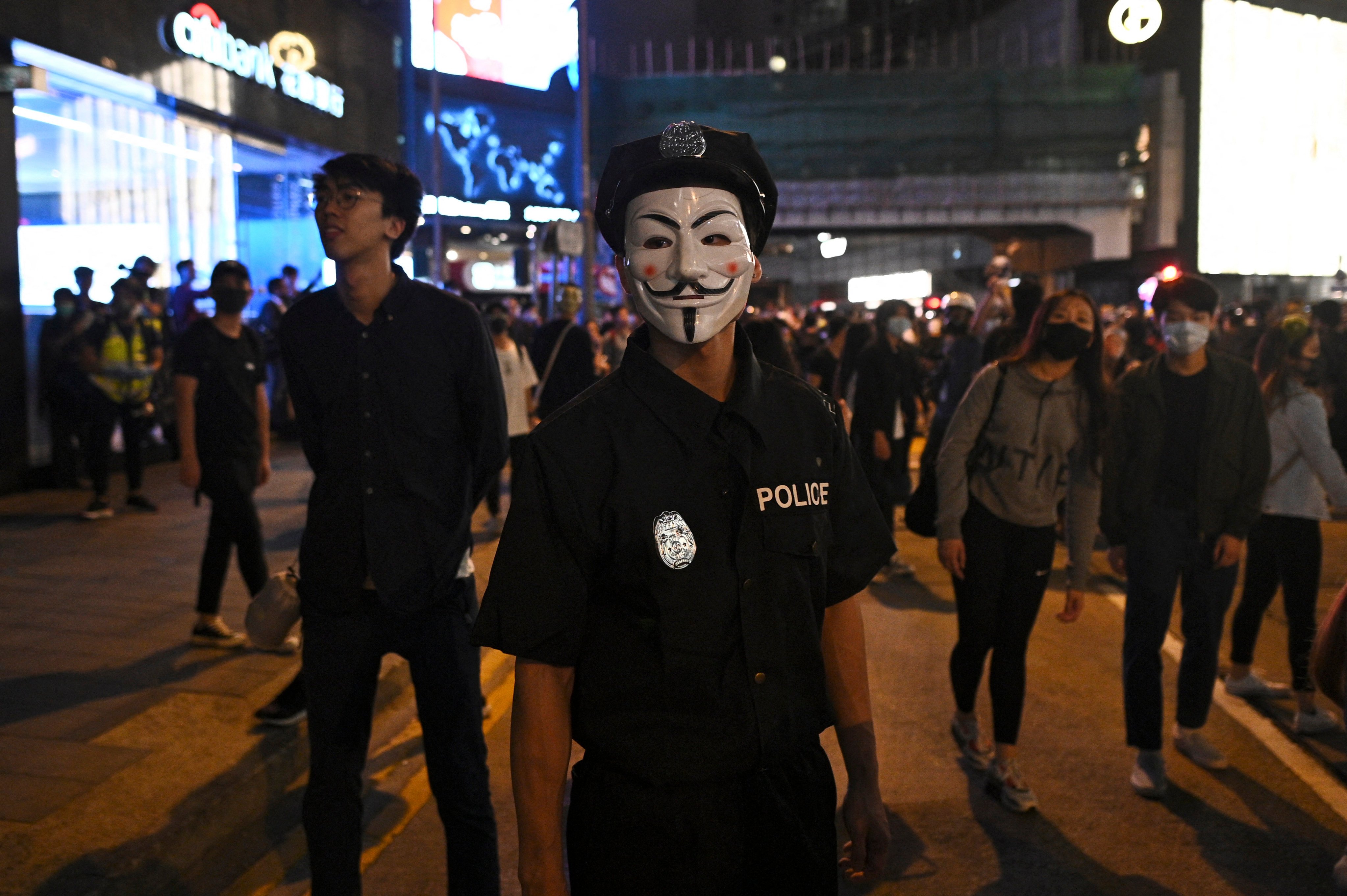 A man dressed in a police uniform stands on a street in Hong Kong during Halloween in 2019. Photo: AFP