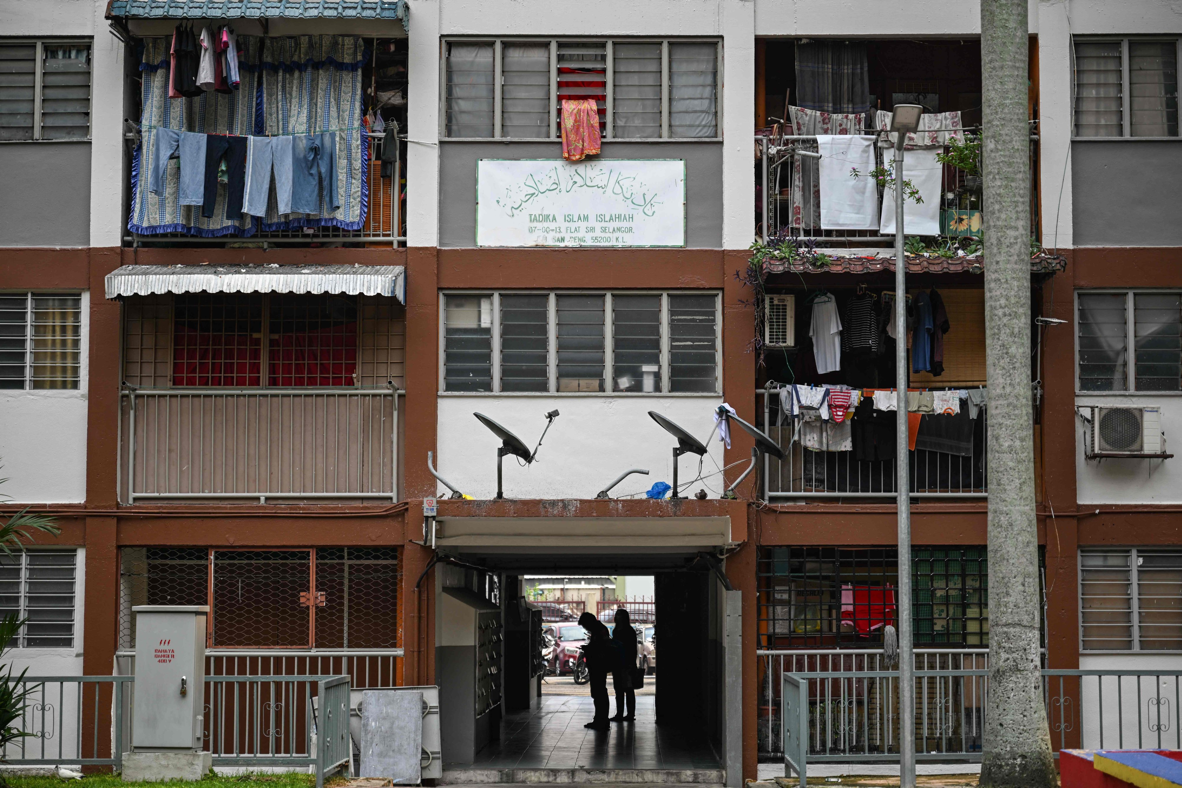 People wait for the elevator at a public housing building in Kuala Lumpur on October 19. Photo: AFP