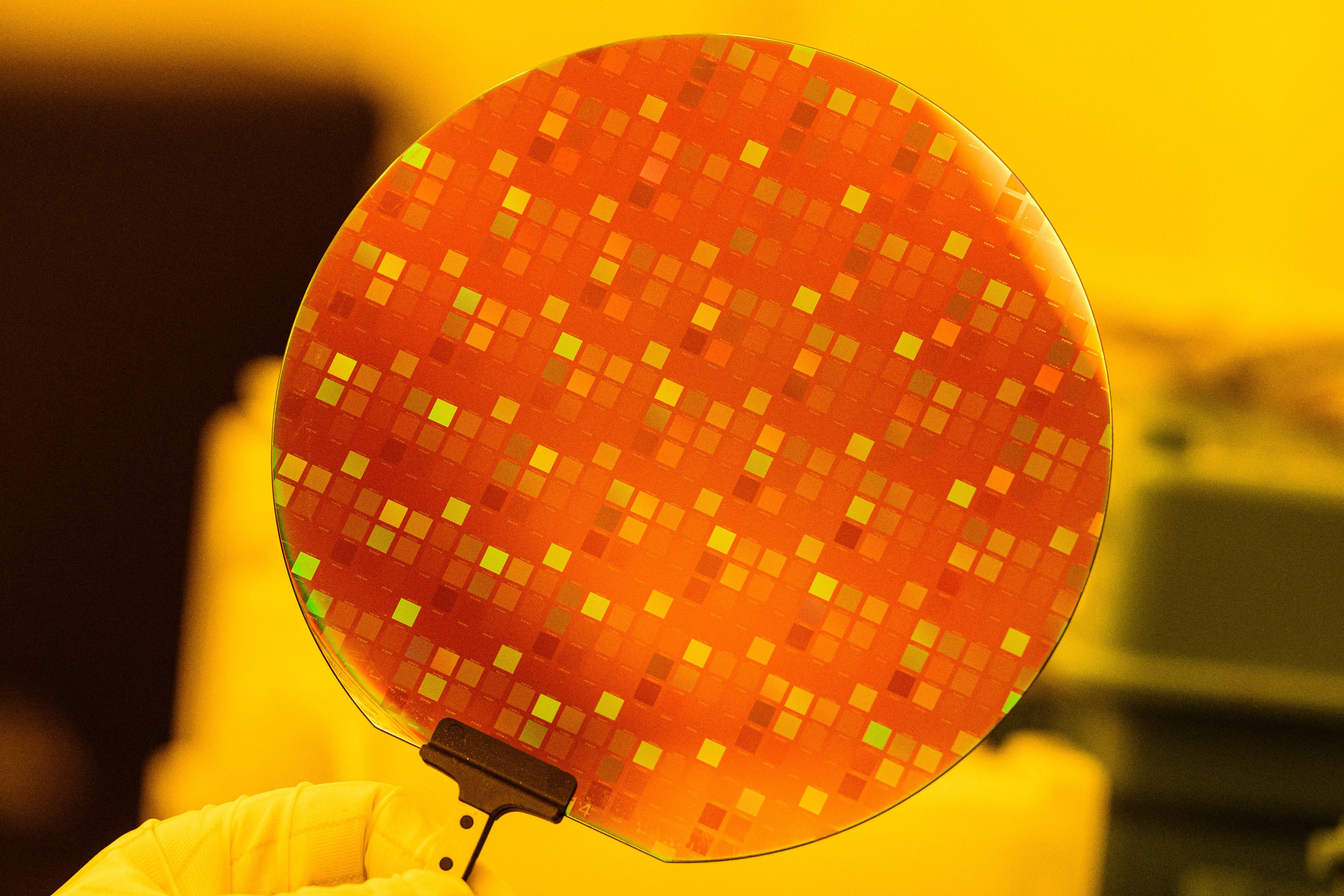 A staff member at Seoul National University’s Inter-university Semiconductor Research Centre holds up a semiconductor wafer. Photo: AFP