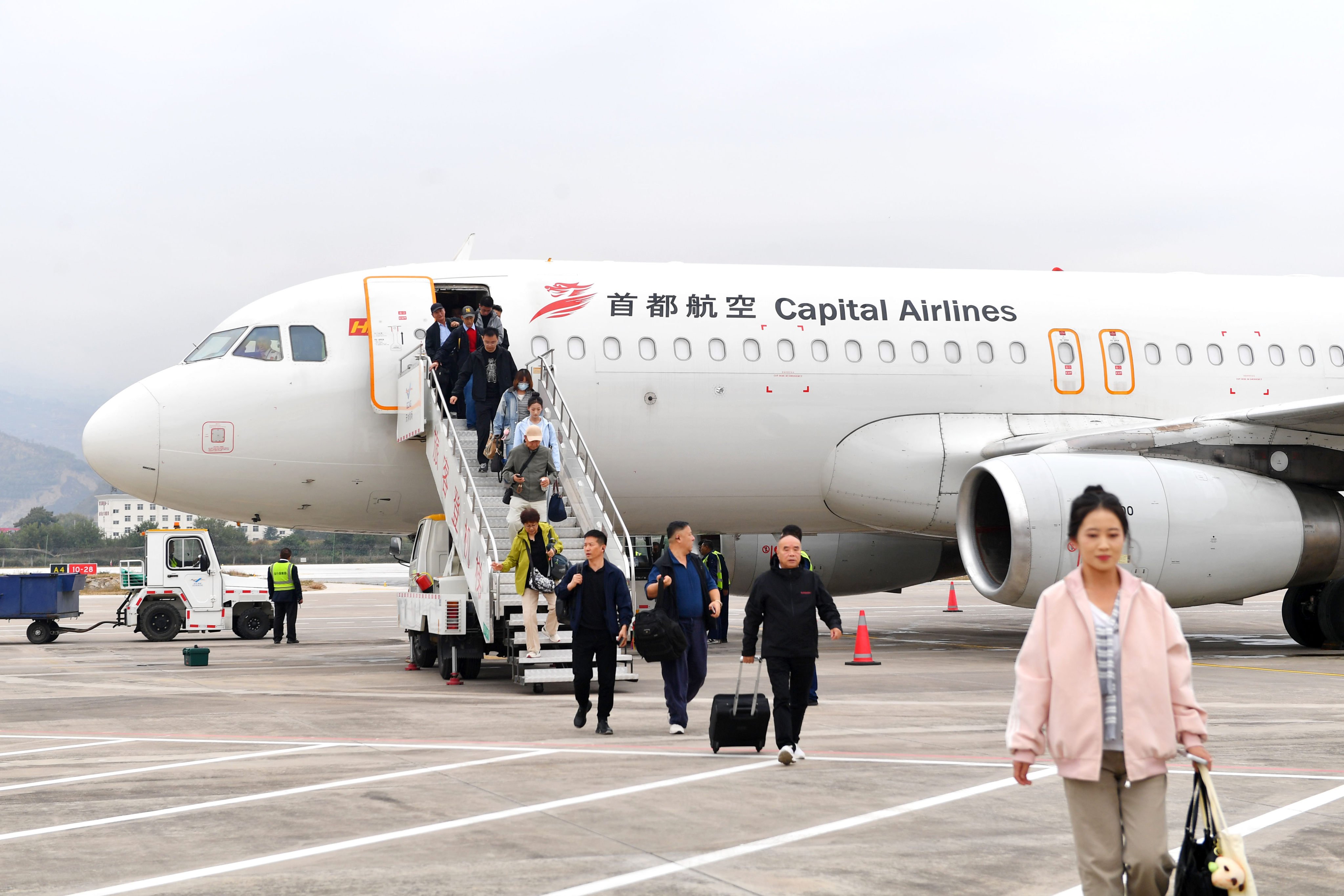Passengers aboard the first direct flight between Beijing and Tianshui disembark at Tianshui Maijishan Airport in Tianshui, northwest China’s Gansu province, on October 11. Photo: Xinhua