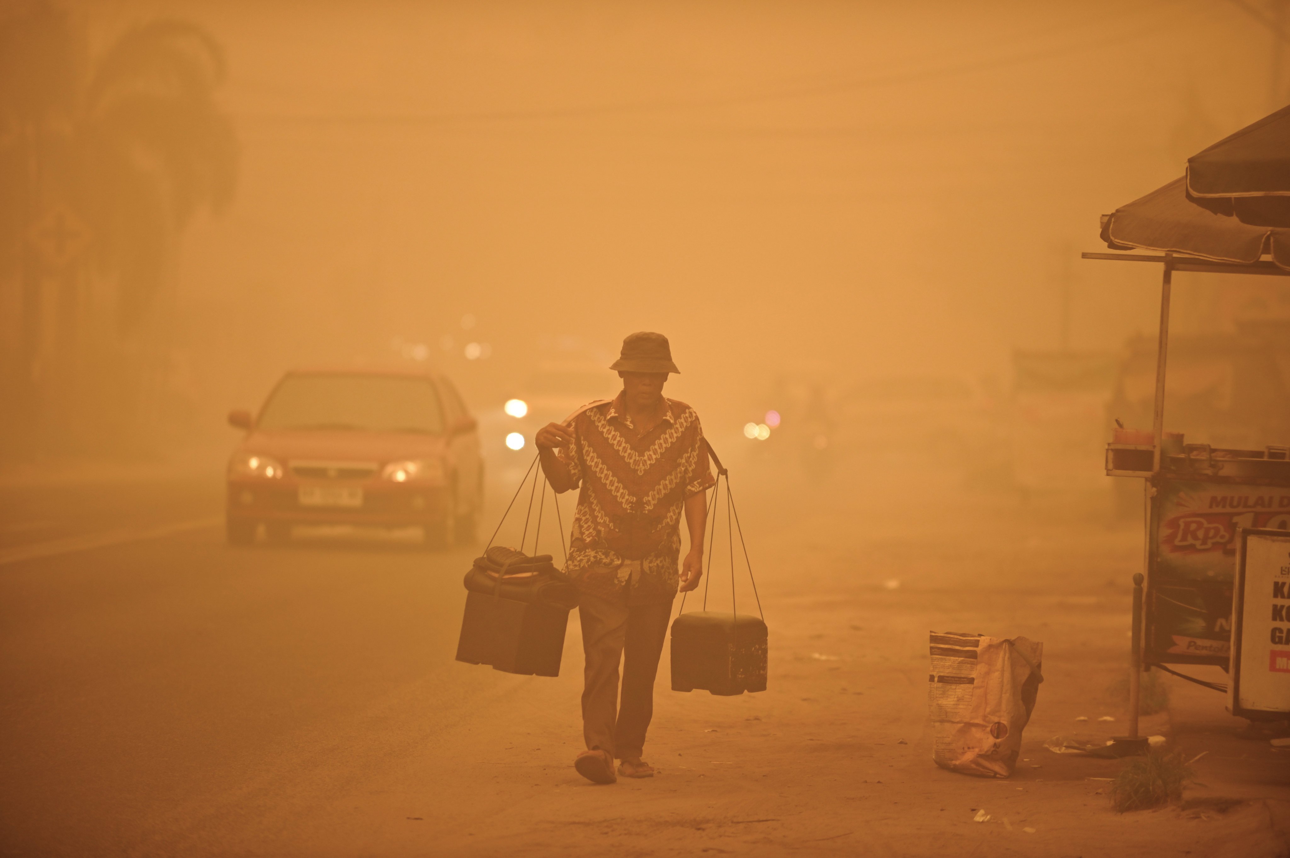 A street vendor walks amid thick haze from wildfires in Palangkaraya, Central Kalimantan, Indonesia, on Saturday. Photo: AP