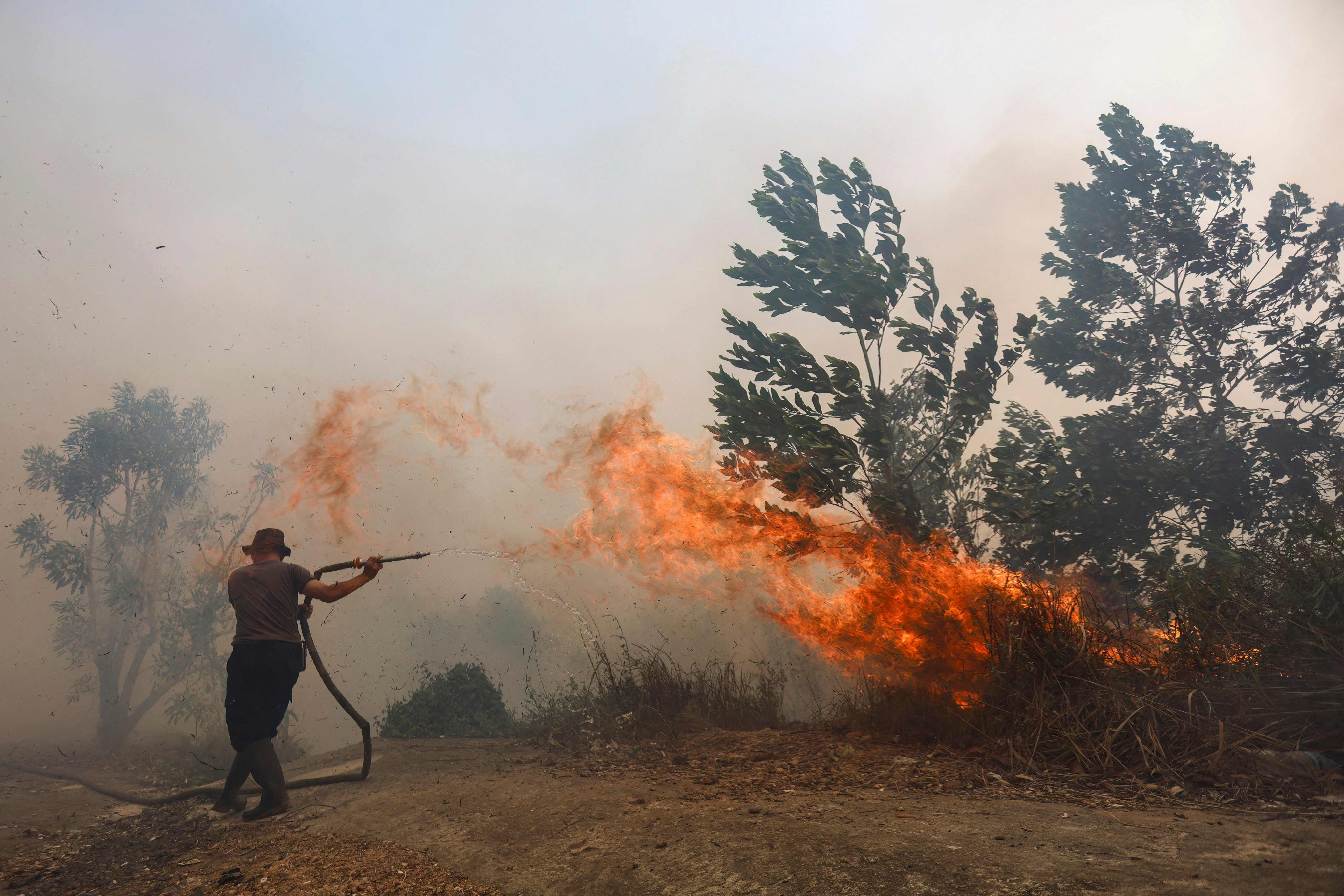 A firefighter battles a fast-moving brush fire amid heavy smoke in South Kalimantan, Indonesia. Photo: AFP