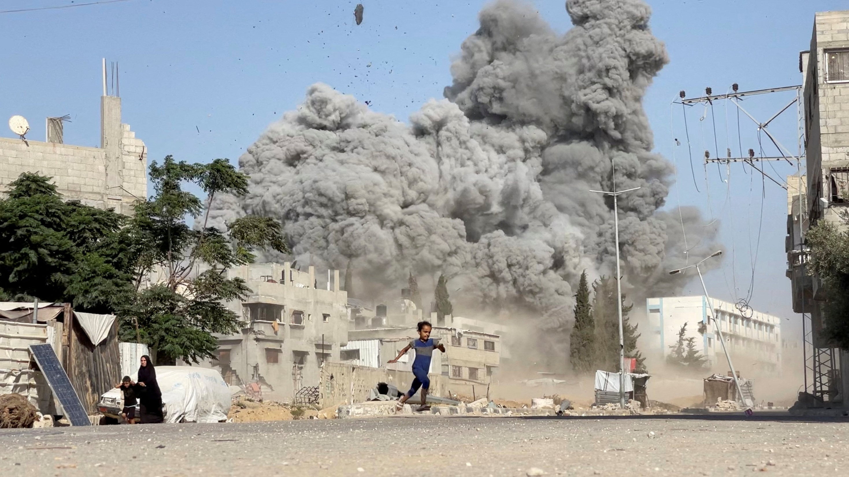 A girl runs from the scene after Israeli strikes on a school sheltering displaced people at the Bureij refugee camp in the central Gaza Strip in July last year. Photo: Reuters