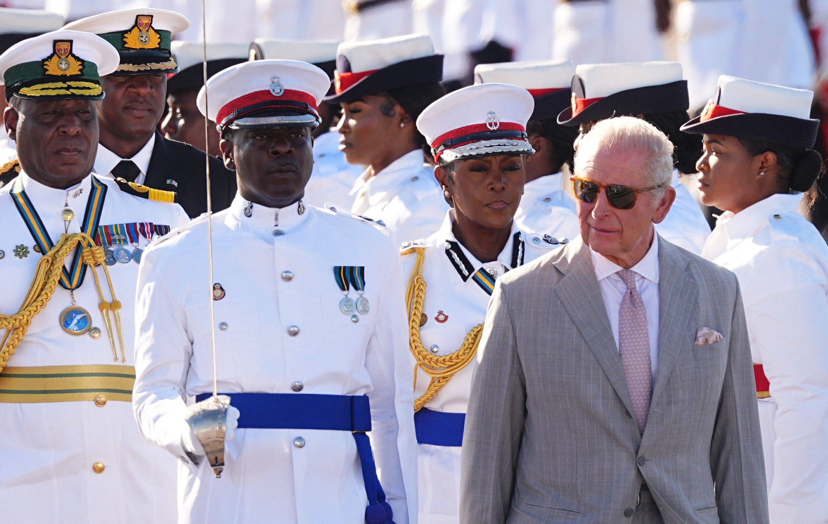 Britain’s King Charles inspects the guard of honour, made up of members of the Royal Bahamas Police Force and the Royal Bahamas Defence Force, as he arrives at Lynden Pindling International Airport in Nassau on Tuesday. Photo: AFP