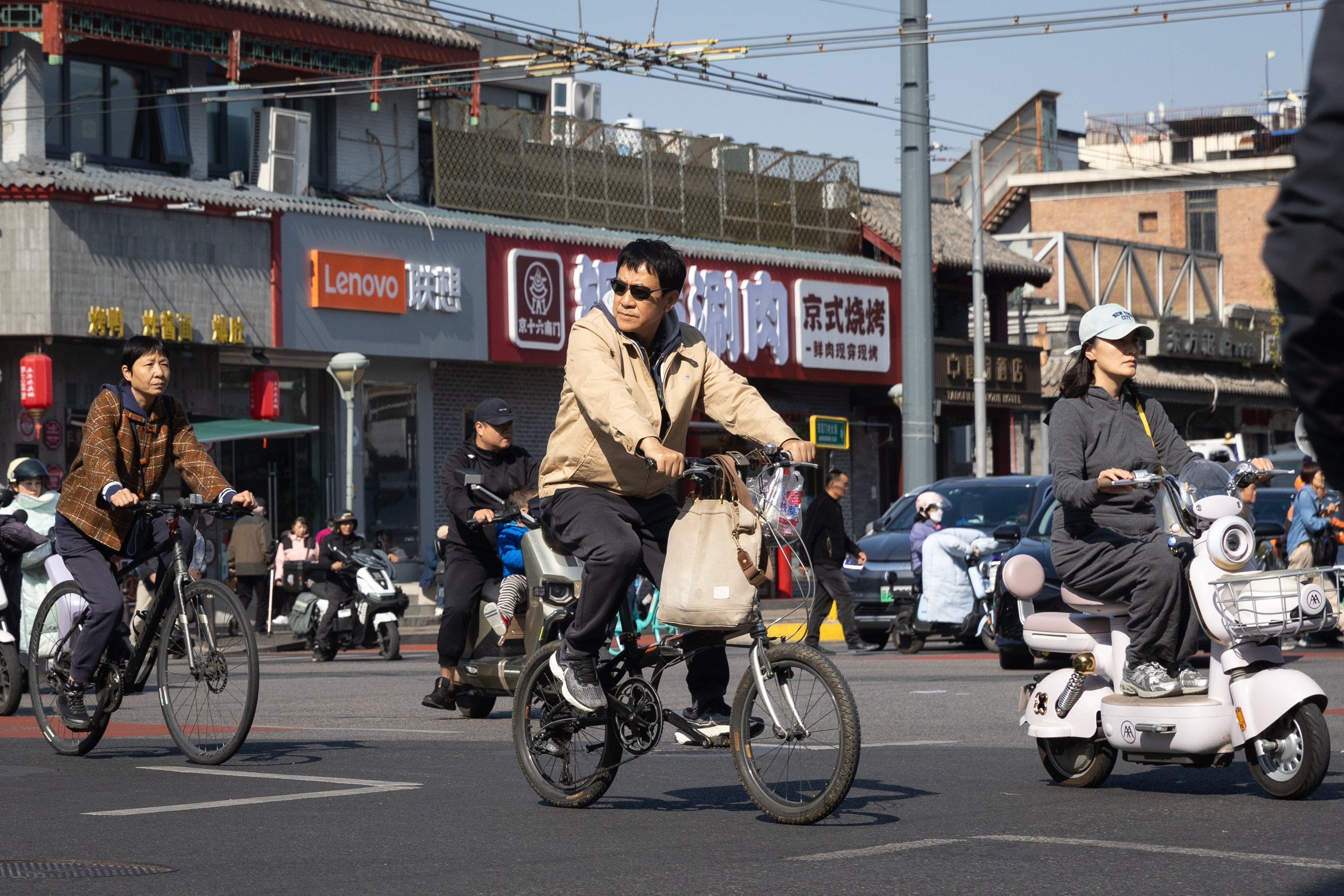 People ride bicycles through an intersection in Beijing on October 19, 2026. Photo: EPA