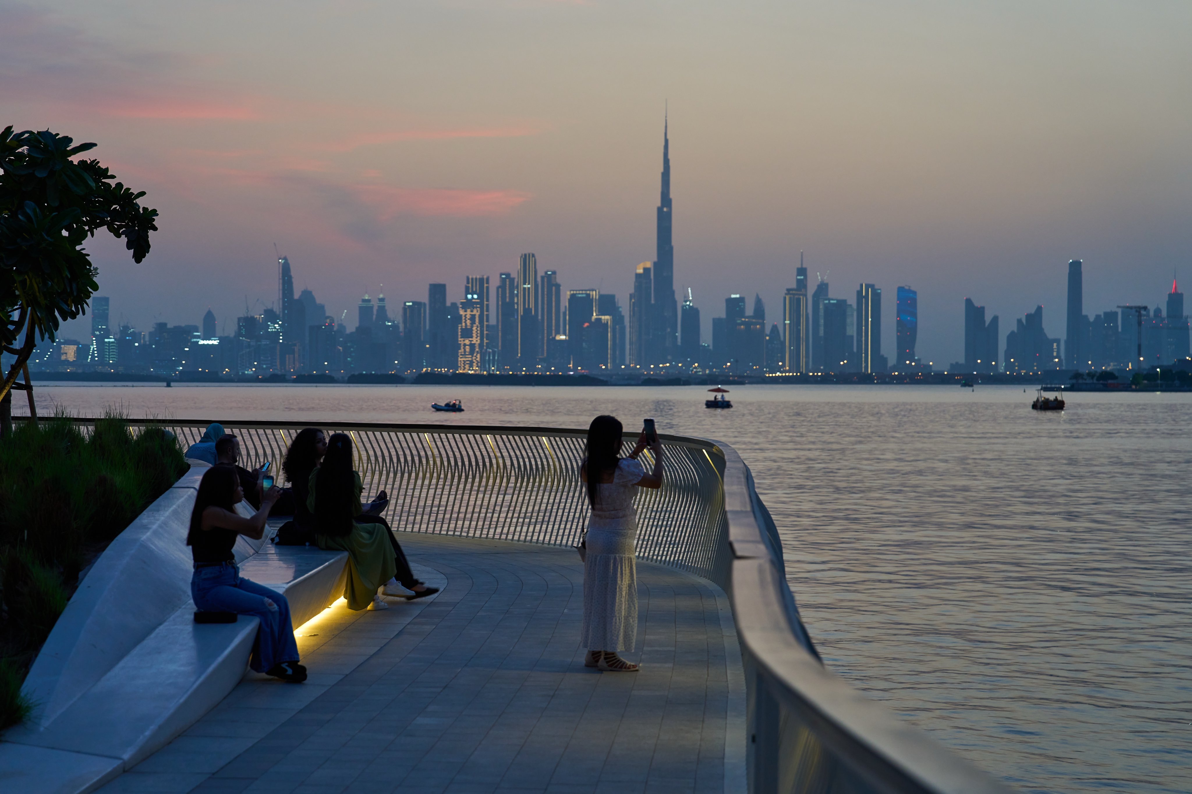 A woman takes photos of the city skyline in Dubai, United Arab Emirates, on October 20. Photo: AP