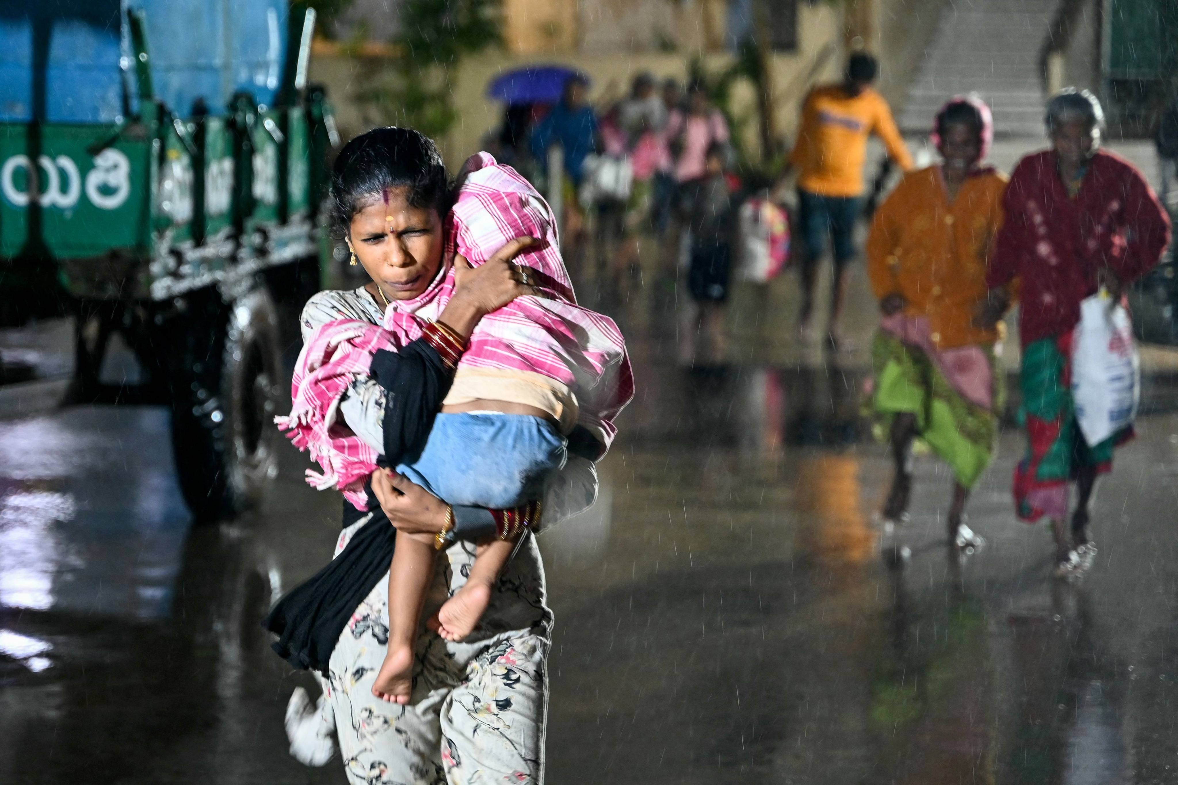 People head to a relief shelter in Andhra Pradesh’s Kakinada on Tuesday ahead of Cyclone Arnab’s expected landfall. Photo: AFP