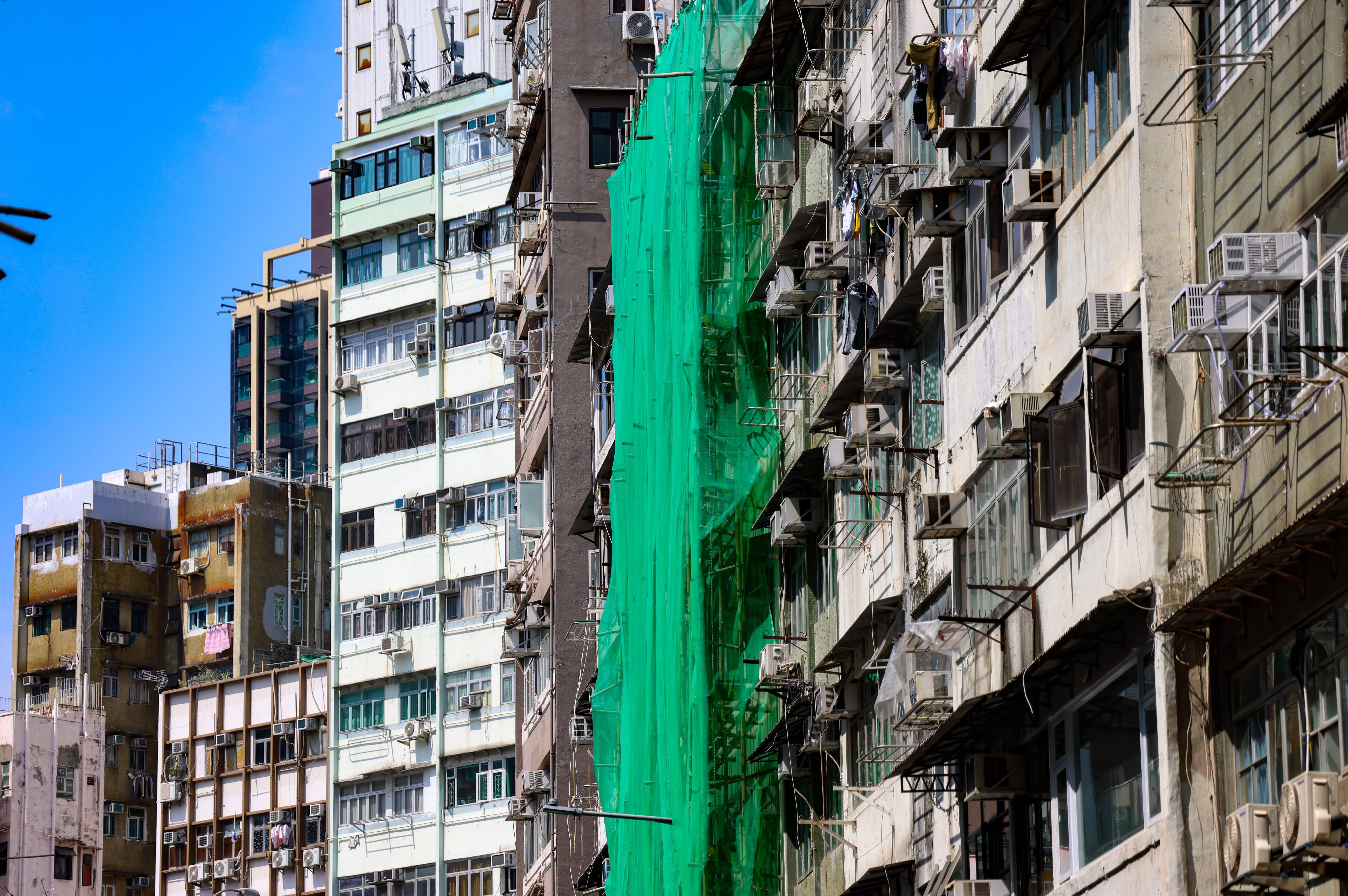 Bamboo scaffolding and protective netting envelope older residential blocks undergoing repair work in Mong Kok. Photo: Silvia Siu
