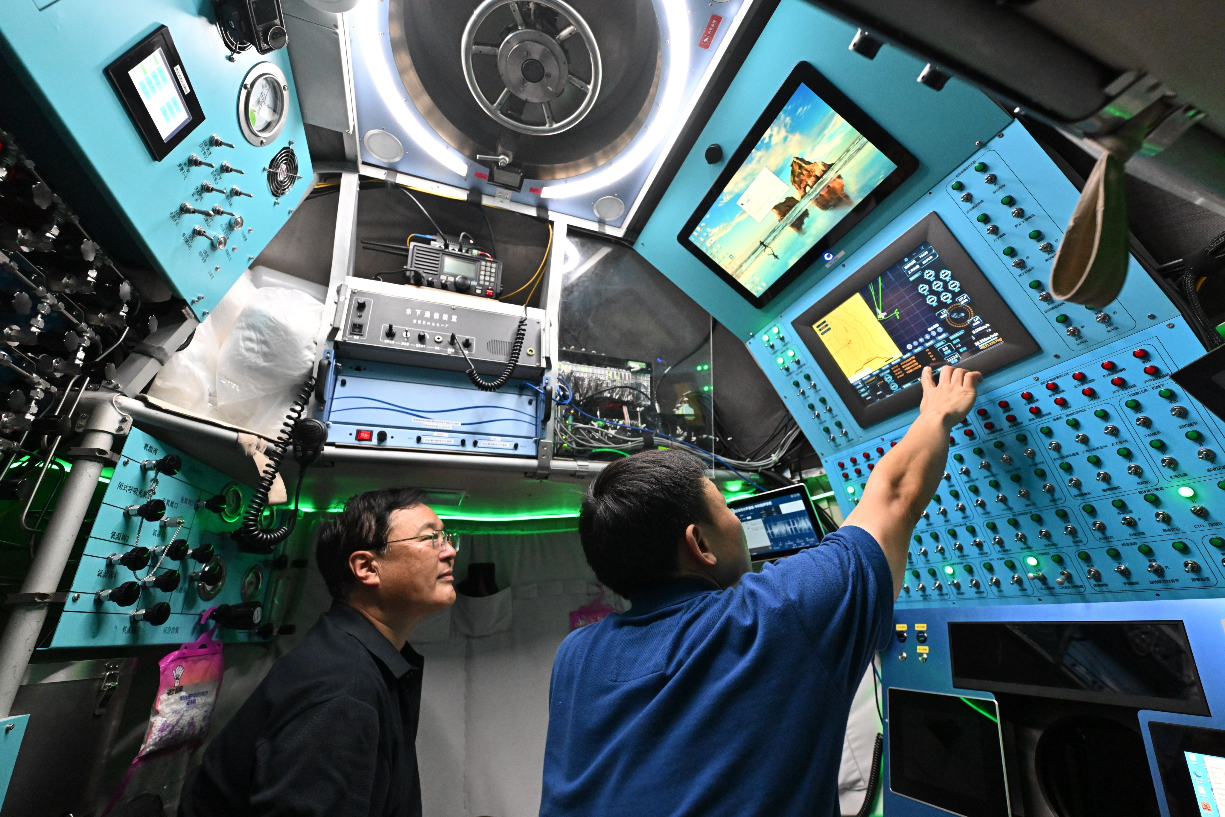 Submersible pilot Tang Jialing (right) checks the manned deep-sea submersible Jiaolong on October 15. Photo: Xinhua
