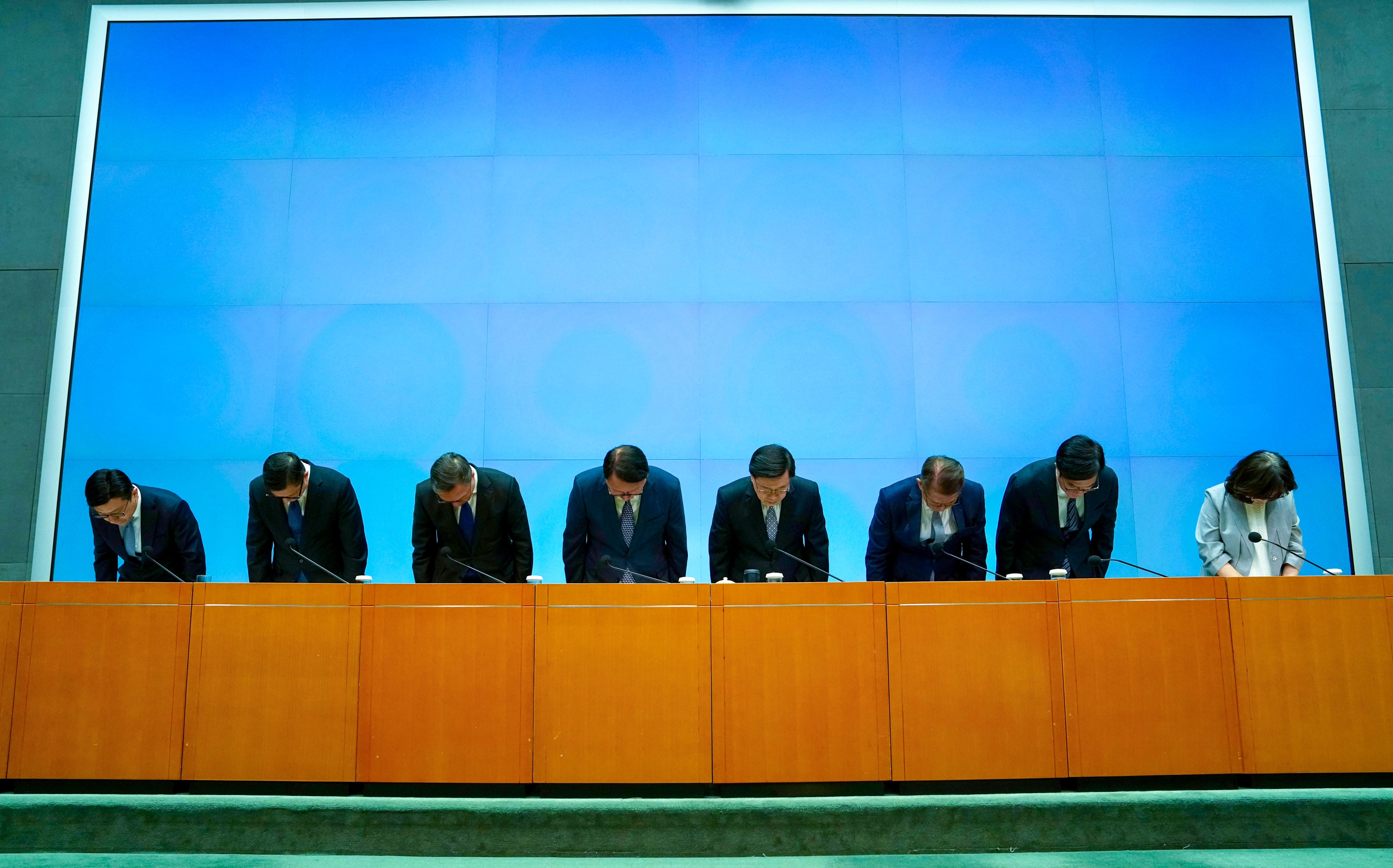 Chief Executive John Lee and fellow officials apologise and bow. Photo: Sam Tsang