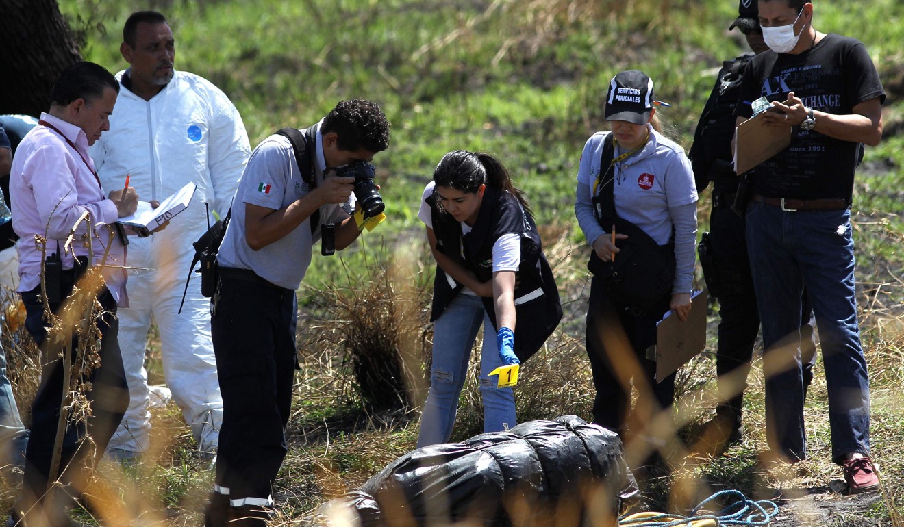 Forensic experts work in the recovery of at least 10 bodies wrapped in bags found in a river channel in Ixtlahuacan de los Membrillos, Jalisco state on March 14, 2019. Photo: AFP