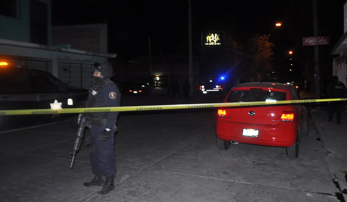 A police officer near a bar La Playa Men’s Club where at least 13 people were killed and seven wounded in a shooting in Salamanca, Mexico on March 9, 2019. Photo: Reuters