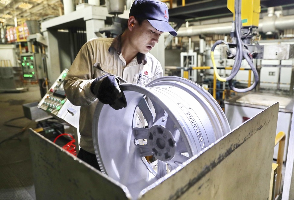 A worker working on an aluminium wheel hub in Qinhuangdao in northern China's Hebei province on February 11, 201. Photo: Chinatopix via AP.