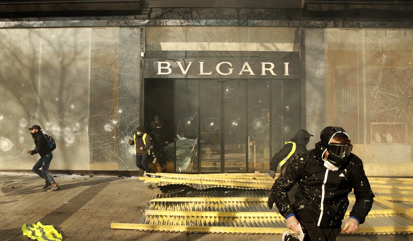 Protesters and looters exit the Bulgari shop on the Champs Elysees during the clashes in Paris. Photo: EPA