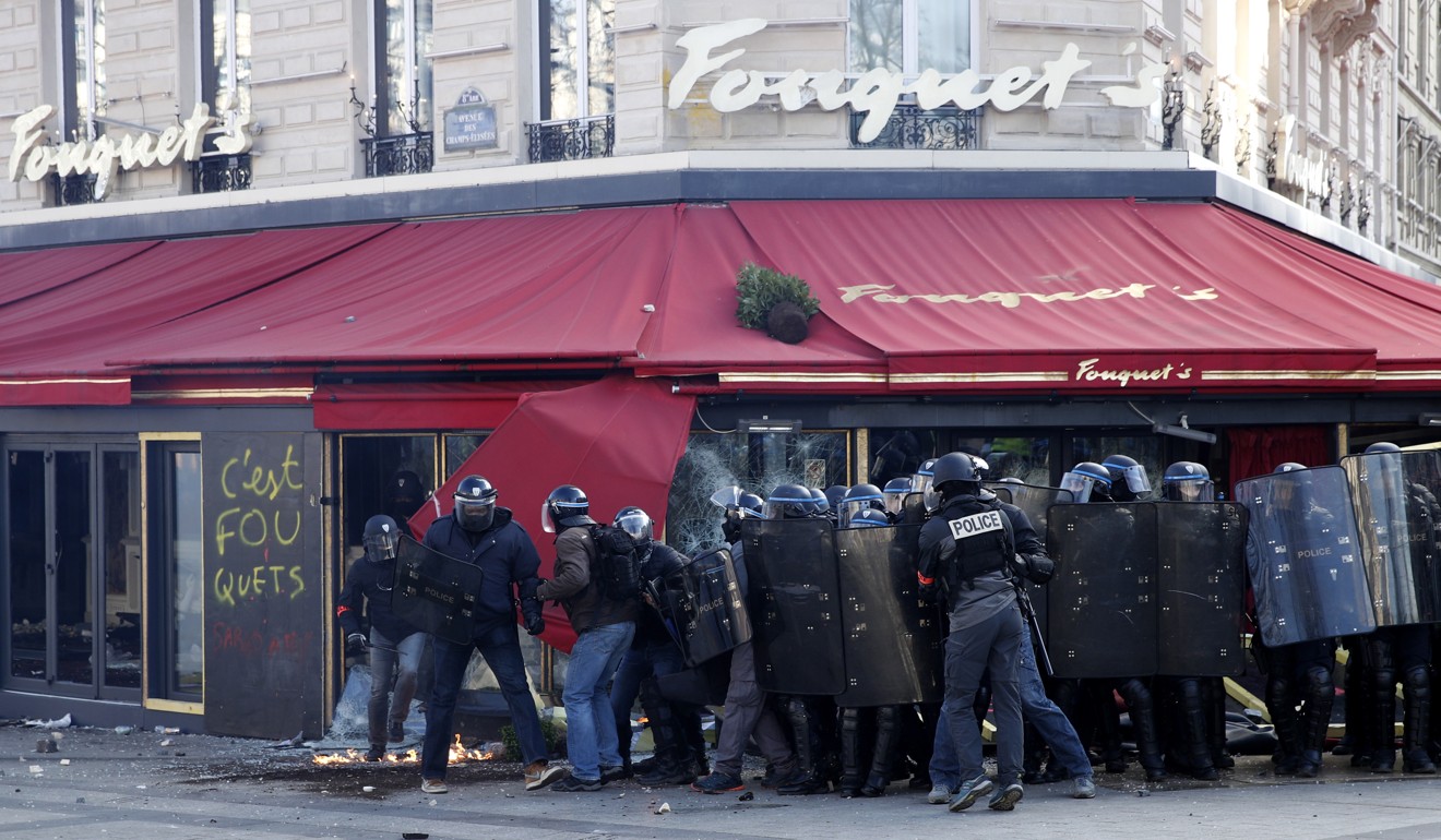 Protesters clash with police in front of Fouquet's brasserie. Photo: EPA