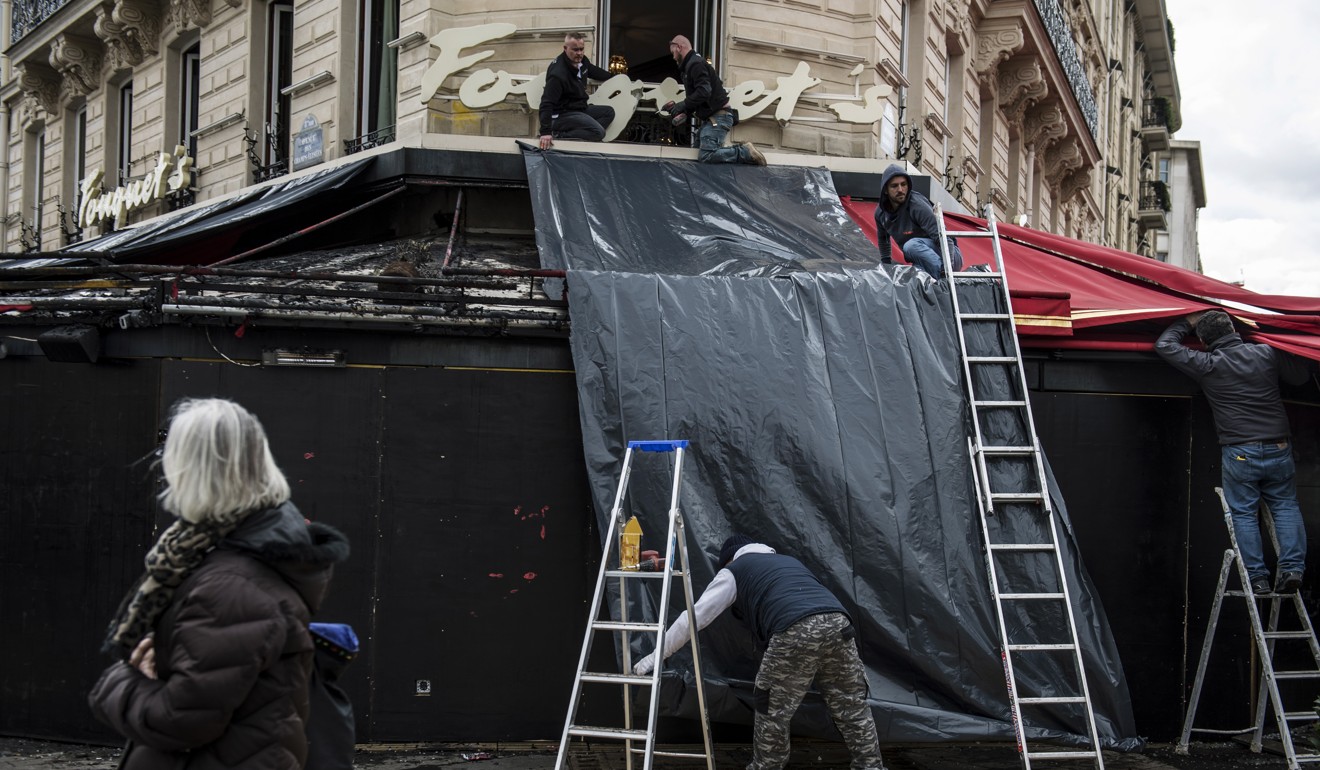Workers check the damage to Fouquet's brasserie. Photo: EPA