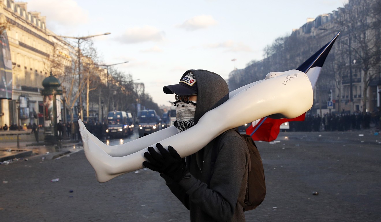 A protester carries a broken mannequin. Photo: EPA