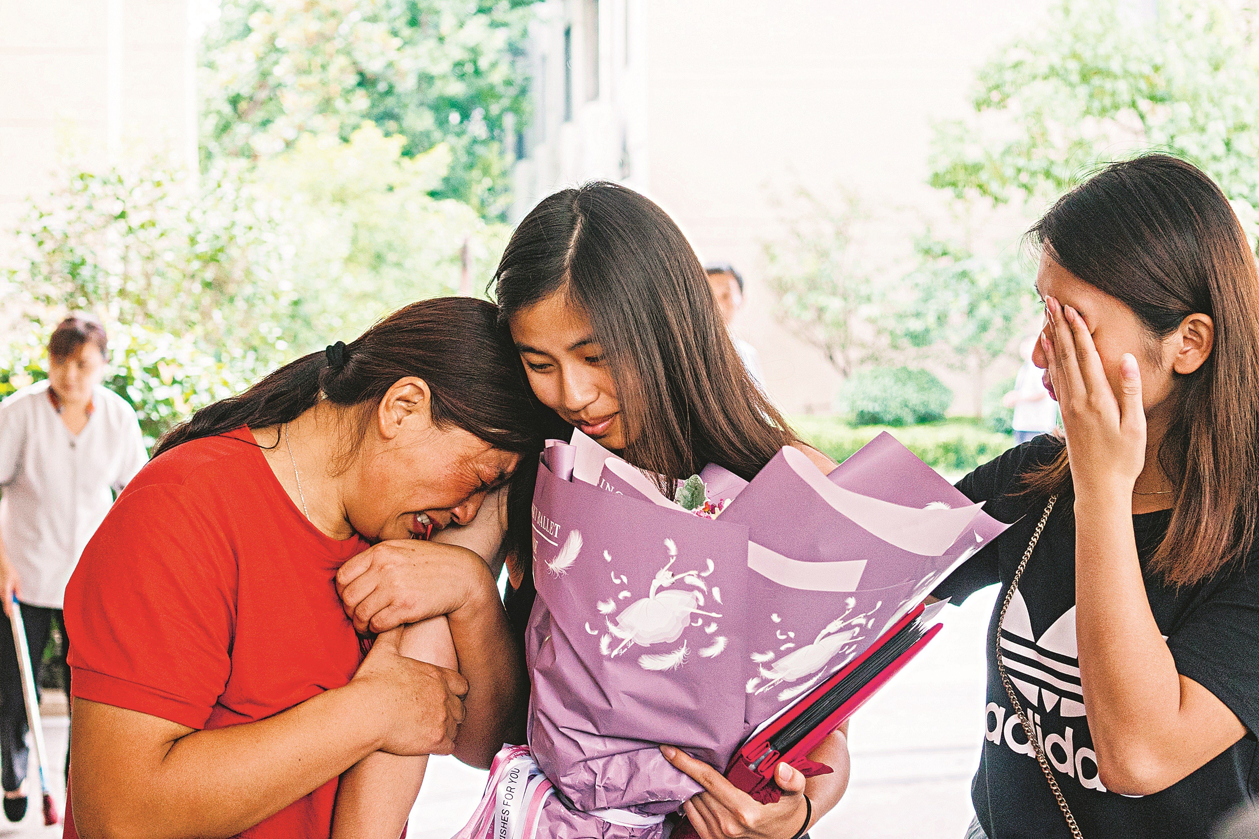 Lianna Fogg (centre), adopted as a child by a couple from Philadelphia in the United States, has an emotional reunion with her biological mother and sister in Anhui province, China. Photo: Zou Biyu