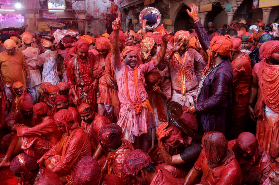 Hindu men from the villages of Nandgaon and Barsana covered with coloured powder and gesturing as they celebrate Lathmar Holi in Barsana. Photo: EPA-EFE