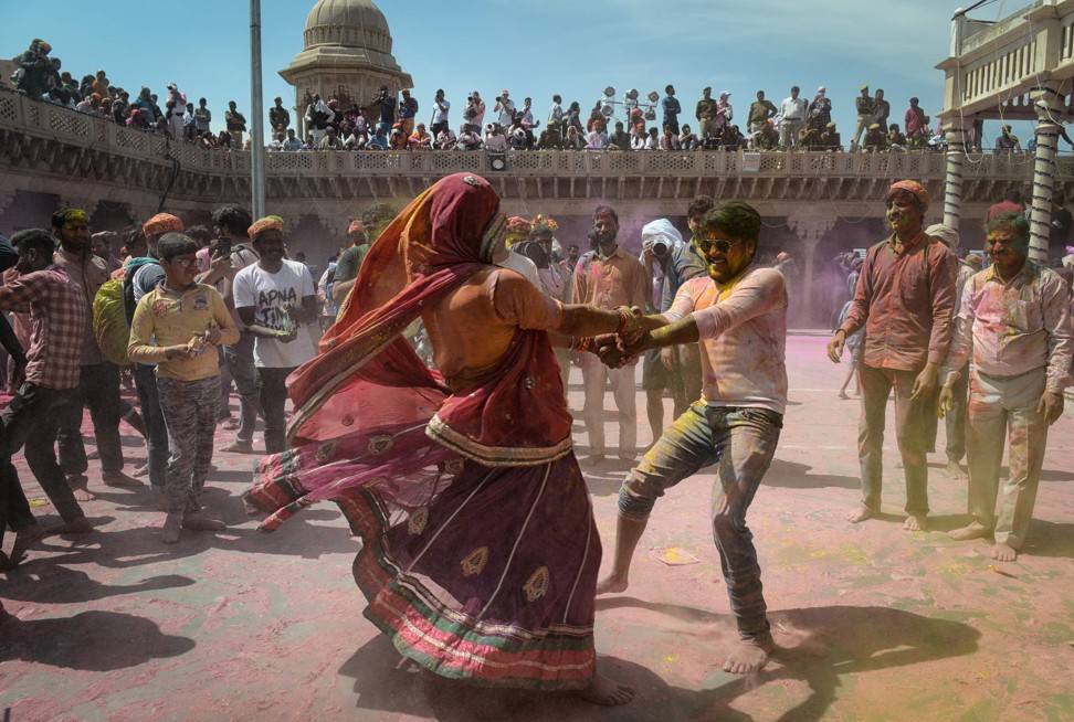 Hindu devotees covered in coloured powder dancing as they celebrate Holi. Photo: AFP