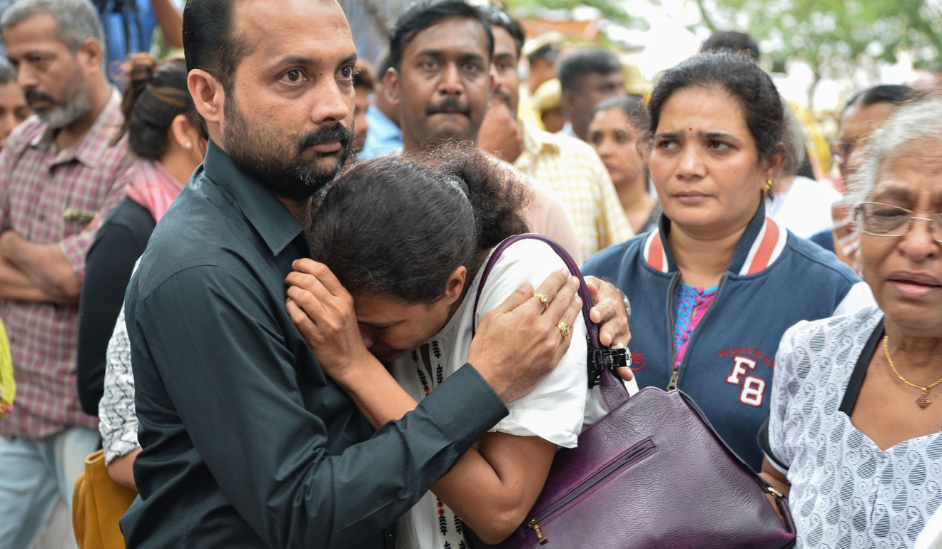 Kavitha Lankesh is consoled by a relative as the body of her sister Indian journalist Gauri Lankesh is brought to the Ravindra Kalakshetra cultural centre in Bangalore. Photo: AFP