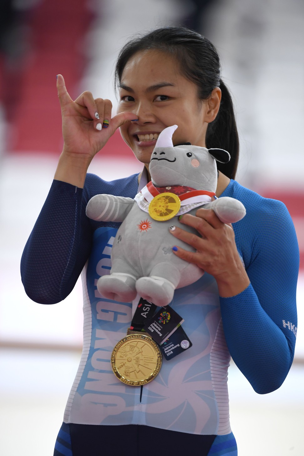 Sarah Lee Wai-sze celebrates on the podium during the awards ceremony for the women’s keirin event in Jakarta. Photo: AFP