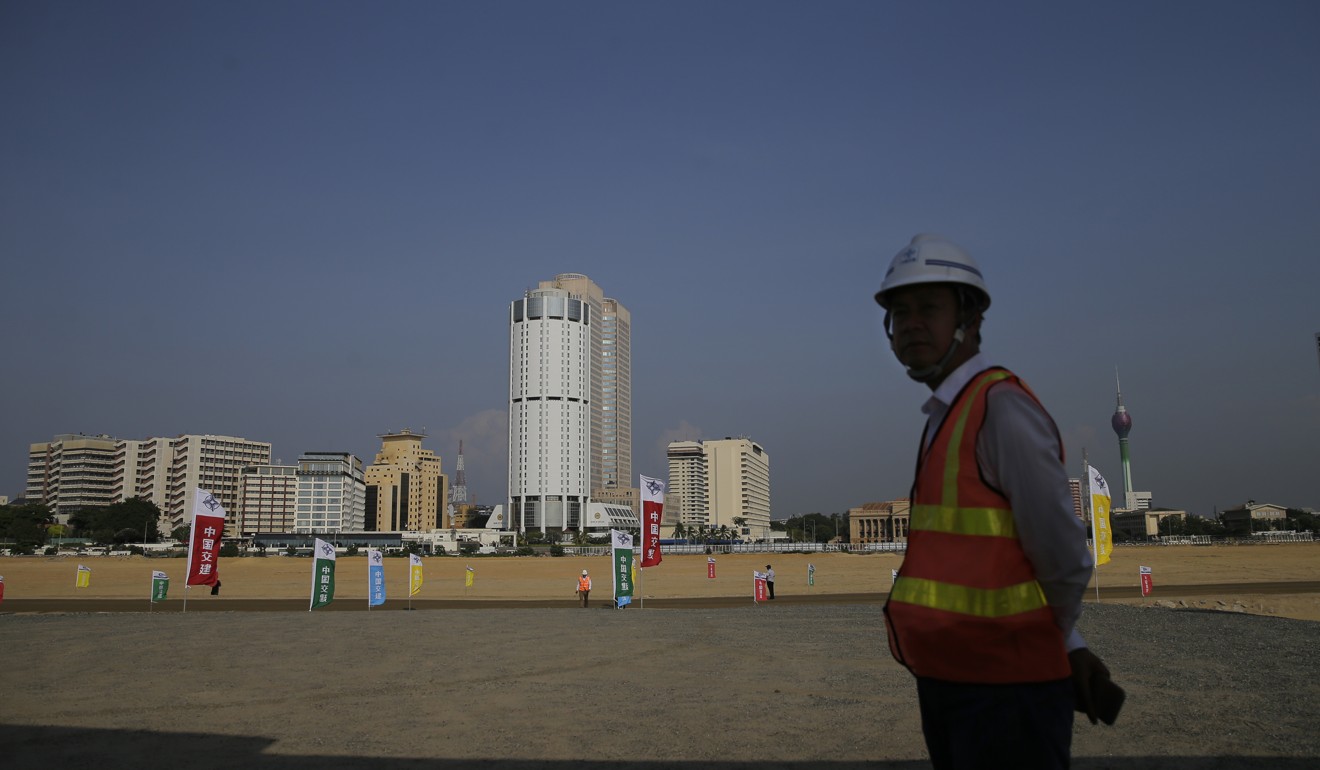 A Chinese construction worker stands on land that was reclaimed from the Indian Ocean for the Colombo Port City project, initiated as part of China’s Belt and Road initiative. Photo: AP Photo