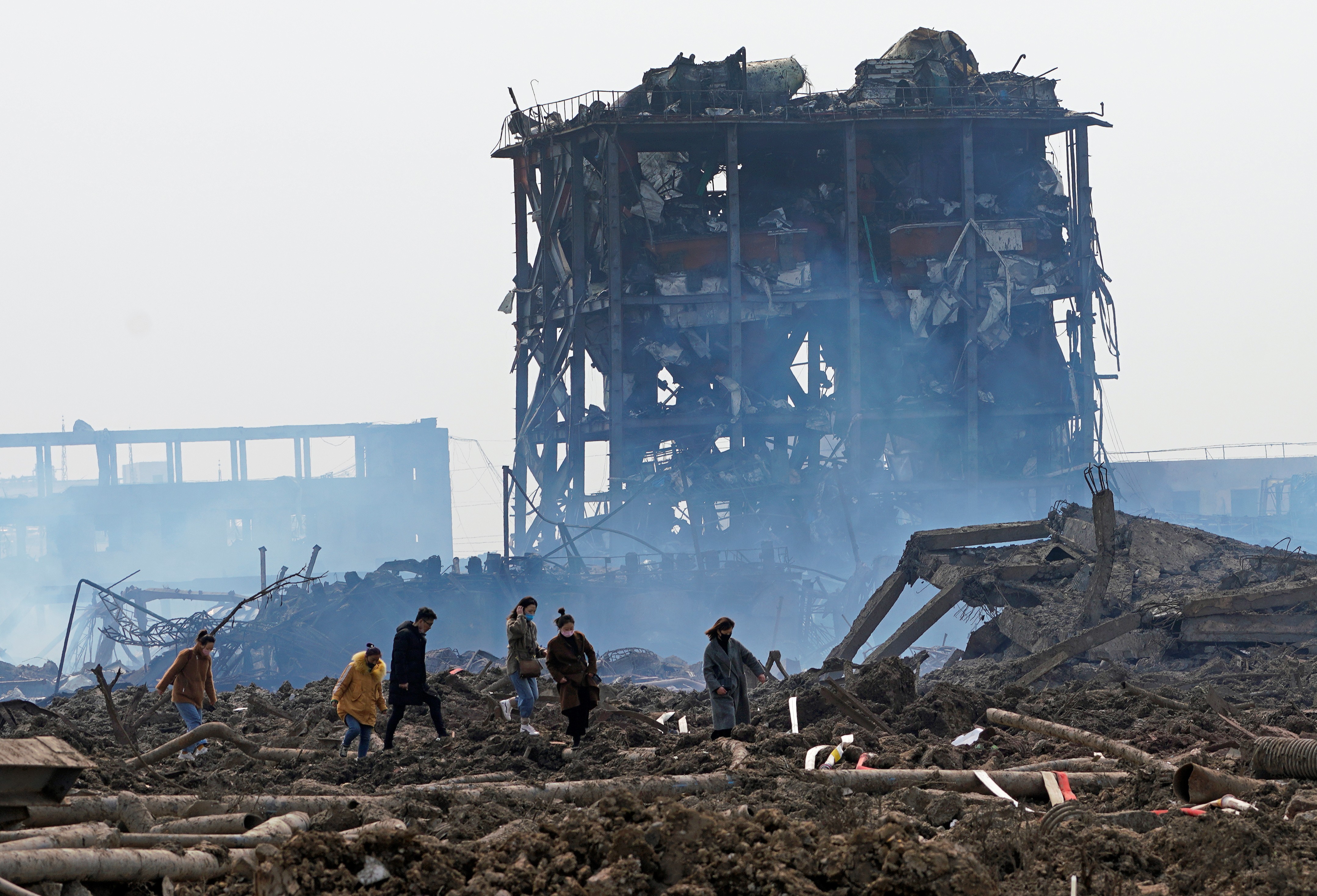 Relatives look for a missing worker at the site of the chemical factory blast. Photo: Reuters