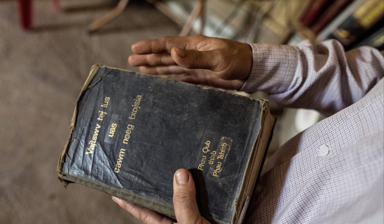 Vang holds a Bible. Photo: Josep Prat