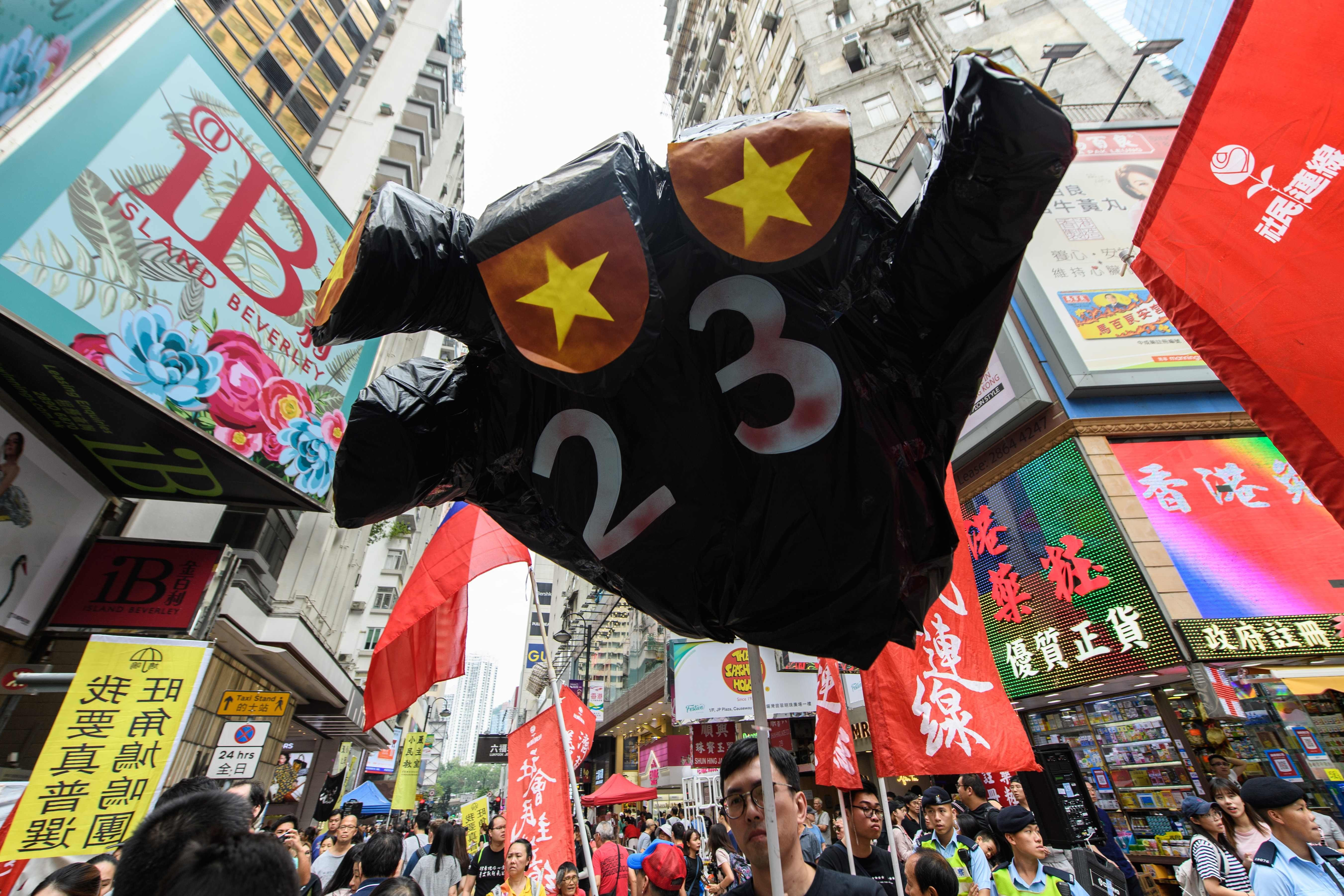 A protester holds up a hand-shaped prop adorned with the colours of the Chinese flag to protest about the possible enactment of Article 23 of the Basic Law at a rally in Hong Kong on October 1, 2018. NPC delegate Peter Wong’s support of national security legislation made him unpopular in some quarters. Photo: AFP