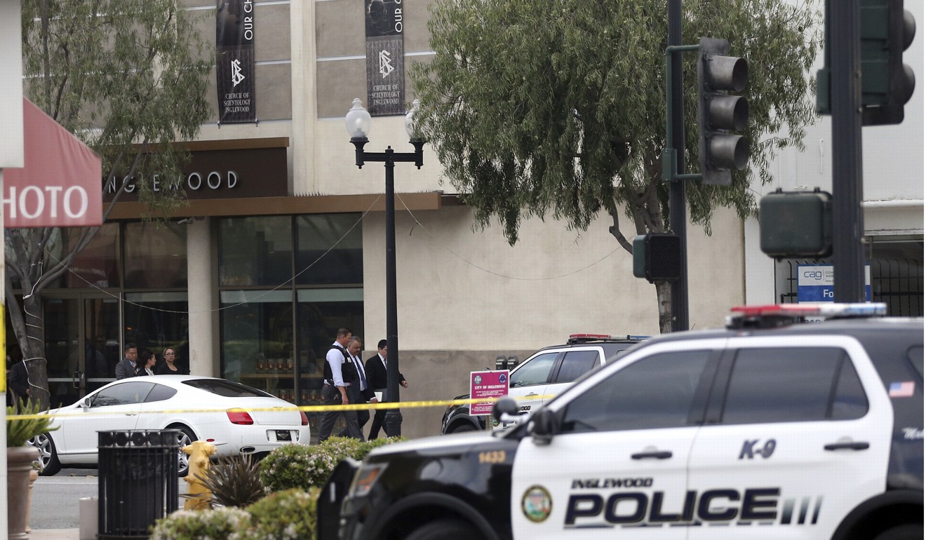 Investigators leave the Scientology building after the shooting. Photo: AP