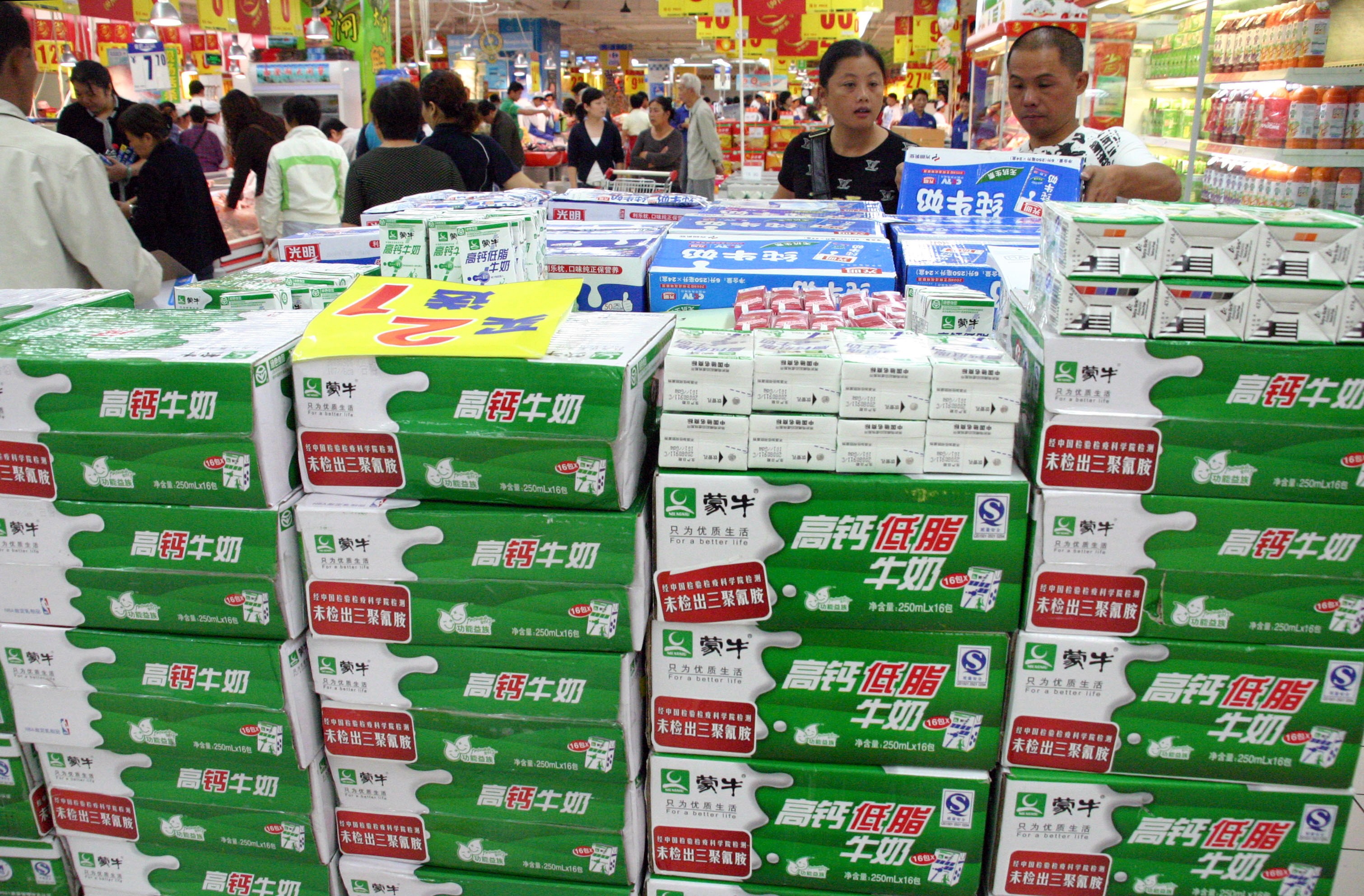 Chinese customers check out milk products at a store in Nanjing. Shares in Mengniu jumped 5.5 per cent to close at HK$27.95 in Hong Kong on Thursday, following the year-end results’ announcement. Photo: AFP