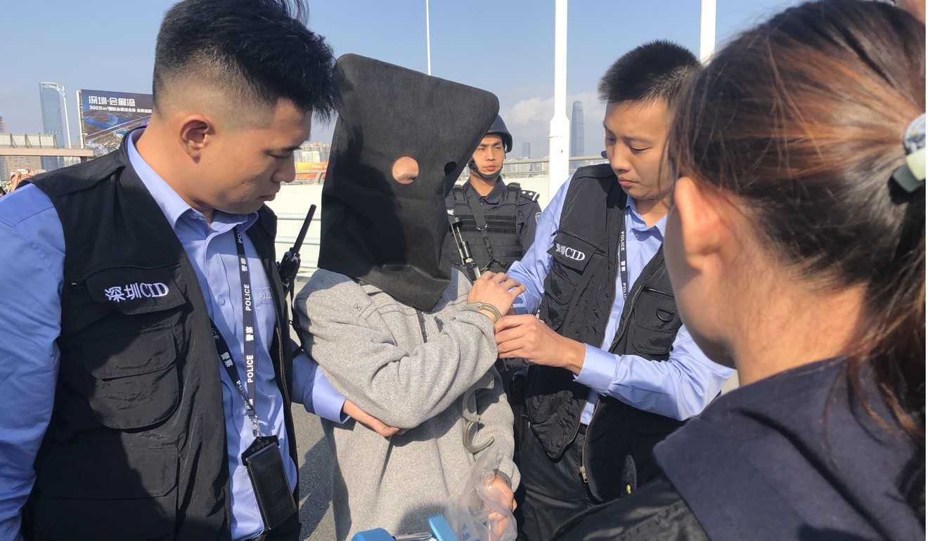Police from China’s Guangdong province hand over a suspect in a robbery case to Hong Kong officers at the Huanggang border checkpoint in July last year. Photo: Edward Wong