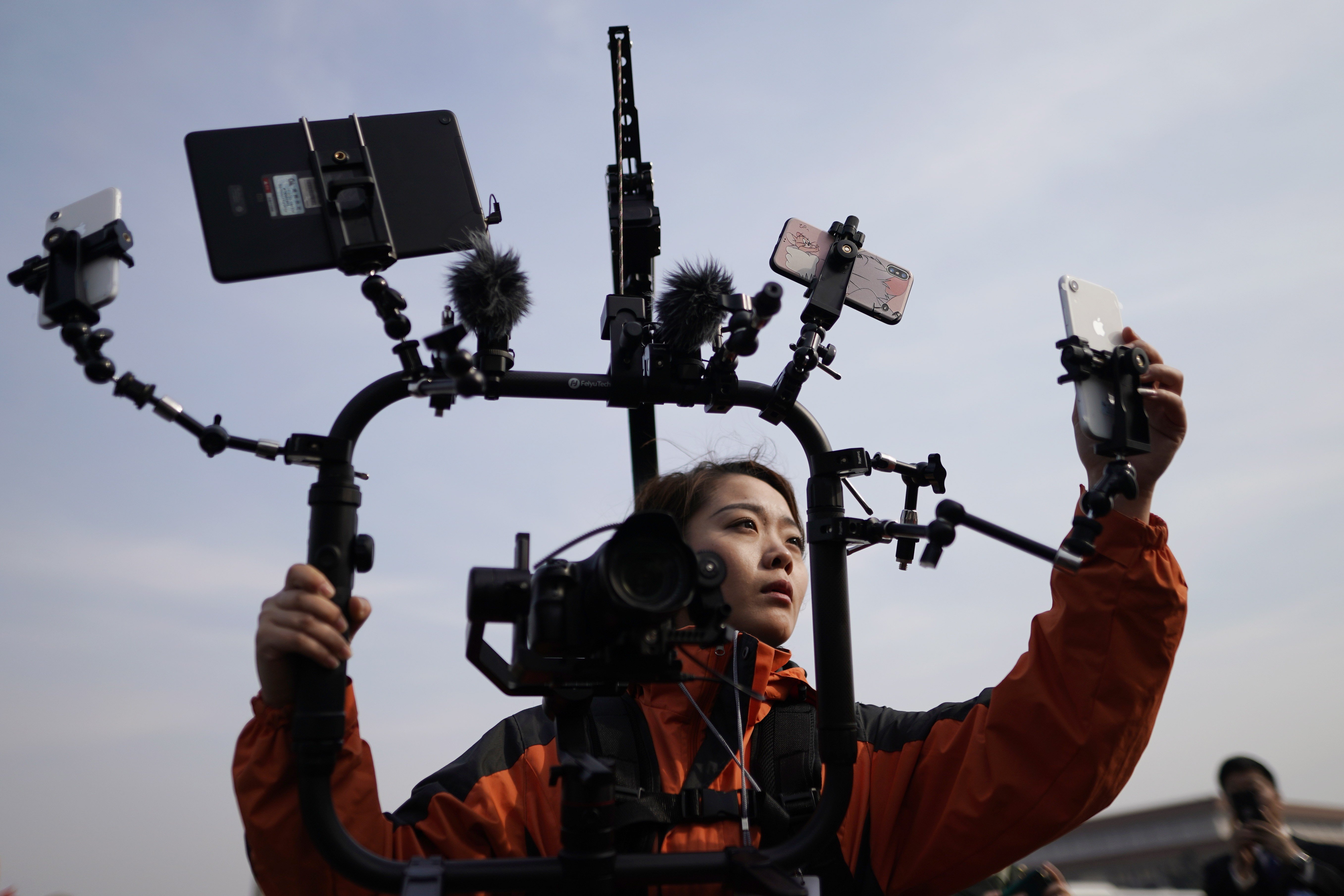 A reporter uses mobile phones for a live broadcast of the National People’s Congress meeting at the Great Hall of the People in Beijing, on March 8. The consumption-focused innovative industries that barely existed in 2008 are increasingly propelling the Chinese economy today. Photo: EPA-EFE