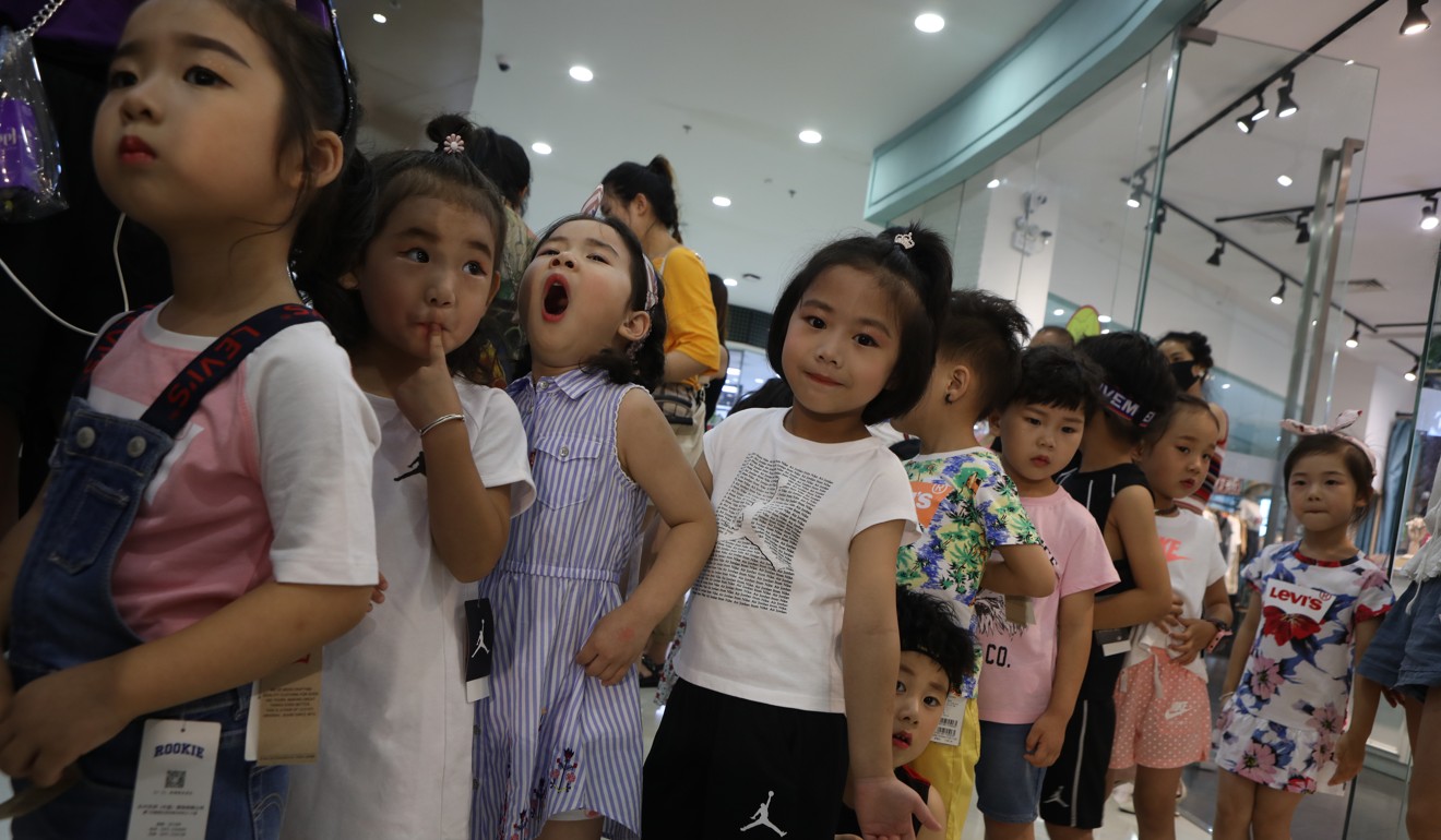 A line of children wait their turn to model clothes for commercials. Photo: Sina