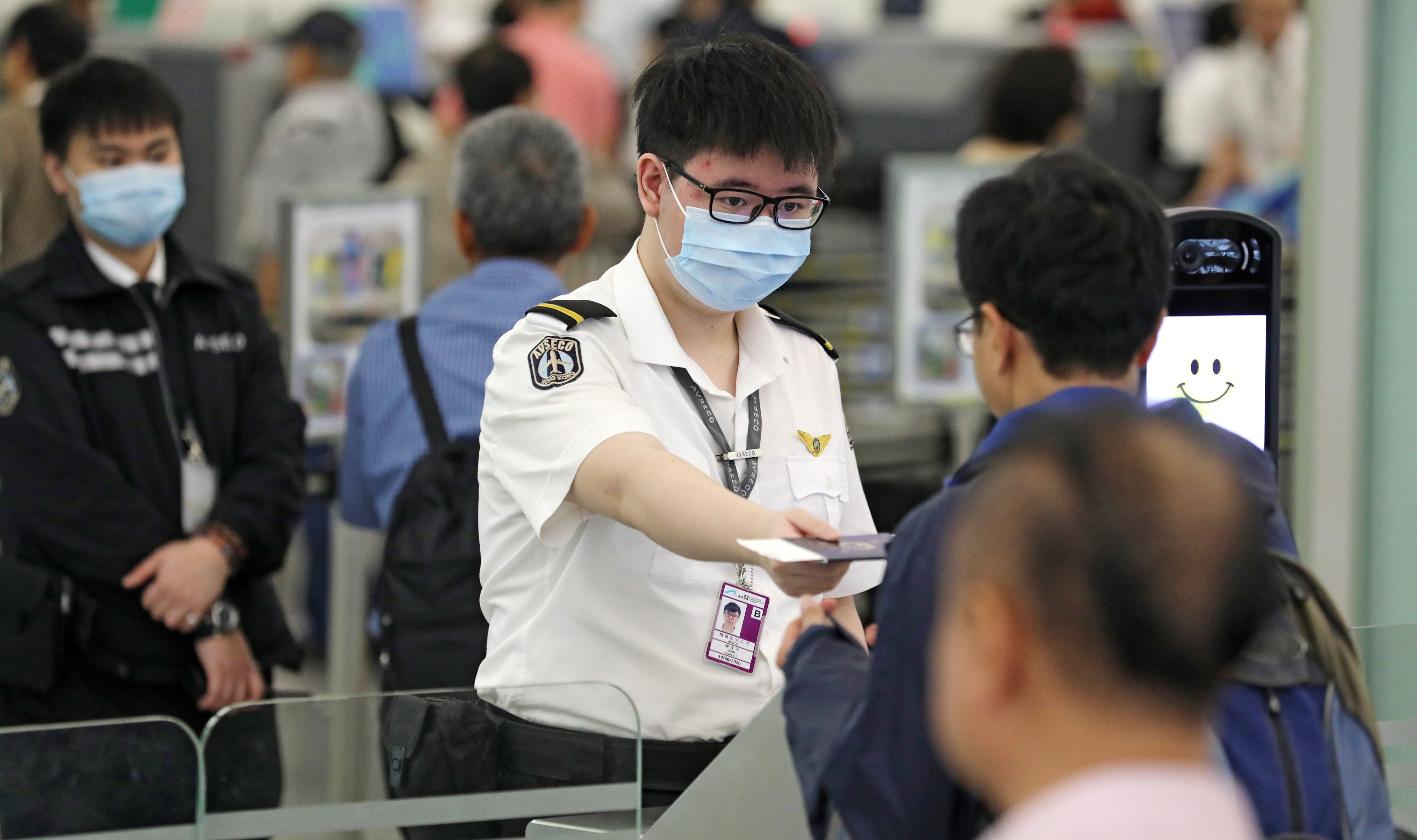 Staff at Hong Kong International Airport in Chek Lap Kok wearing surgical masks amid the outbreak of measles that has stricken the airport. Photo: SCMP Pictures