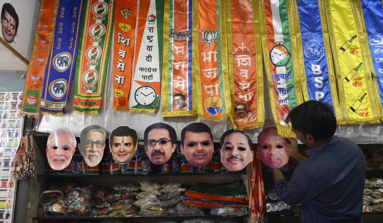An Indian shopkeeper puts up face masks featuring the country’s political leaders. Photo: AFP