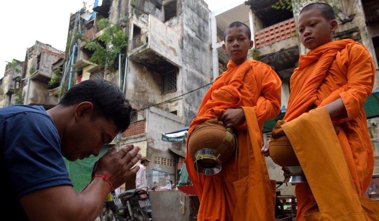 A Cambodian man prays to Buddhist monks at the residential complex known as the White Building before its demolition in Phnom Penh. Photo: AFP