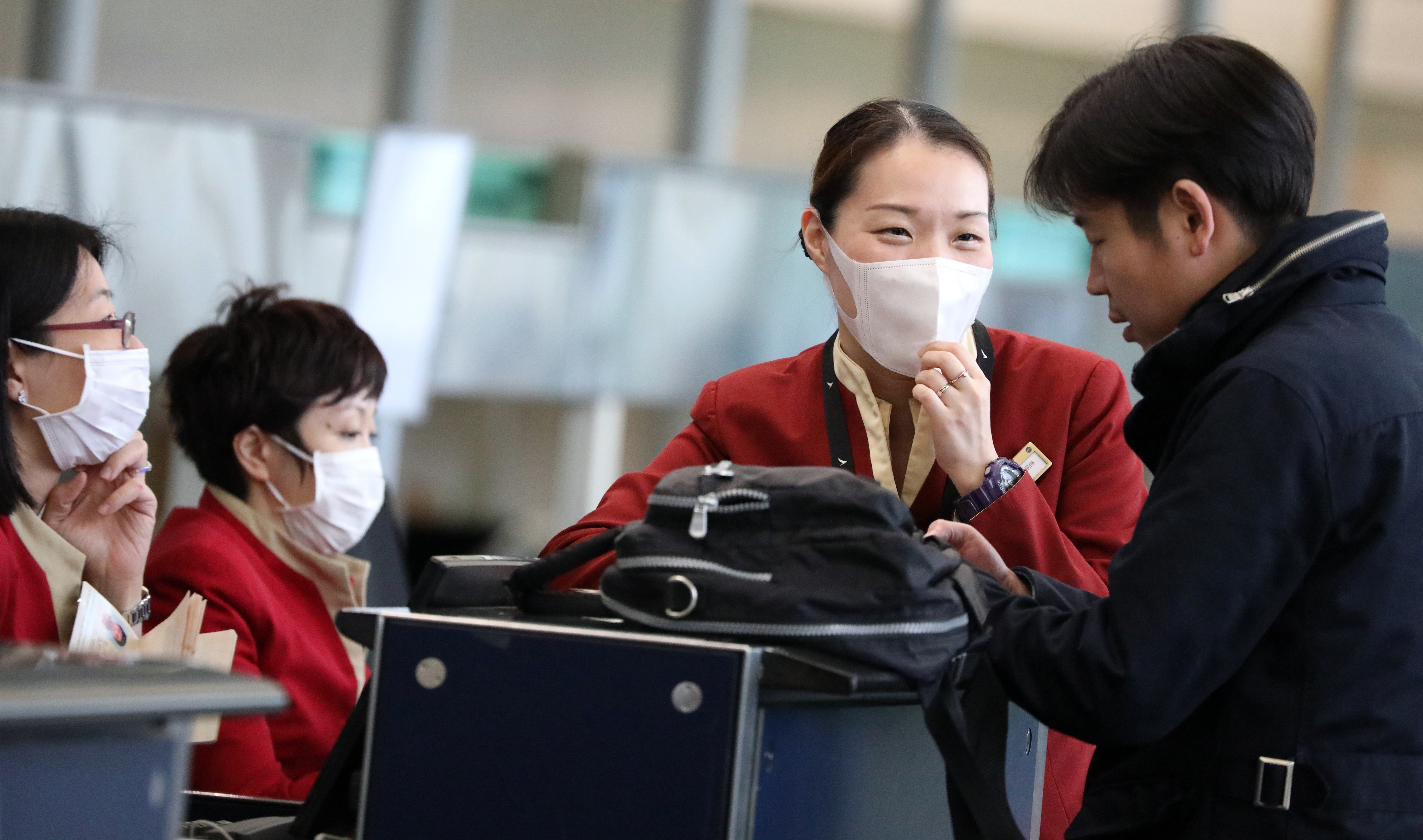 Cathay Pacific ground staff wear face masks at check-in counters at the Hong Kong International Airport on March 24, in the early days of the measles outbreak. Pregnant Cathay flight attendants a few days later threatened to go on mass sick leave unless the airline improved its safeguards. Photo: Nora Tam