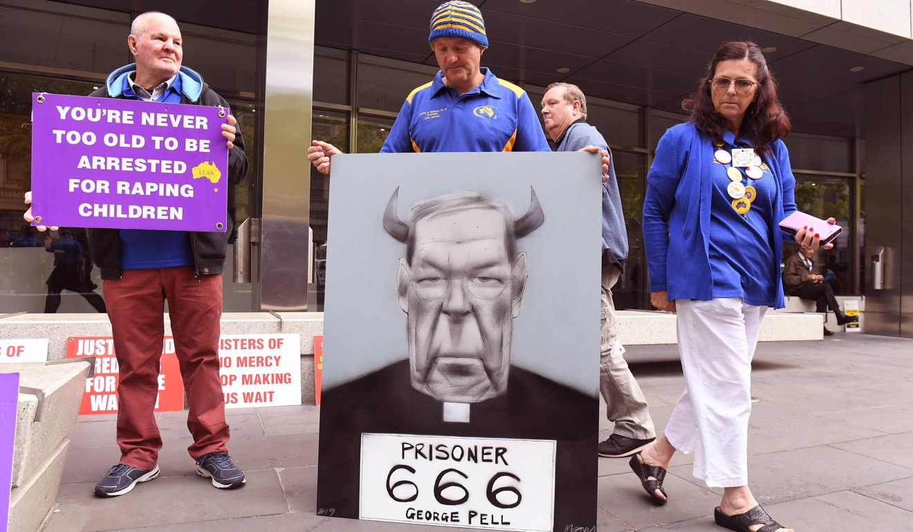Survivors of church abuse hold placards outside at the County Court to hear the sentencing of Cardinal George Pell who was was found guilty on historic child sex crimes, in Melbourne on March 13, 2019. Photo: AFP