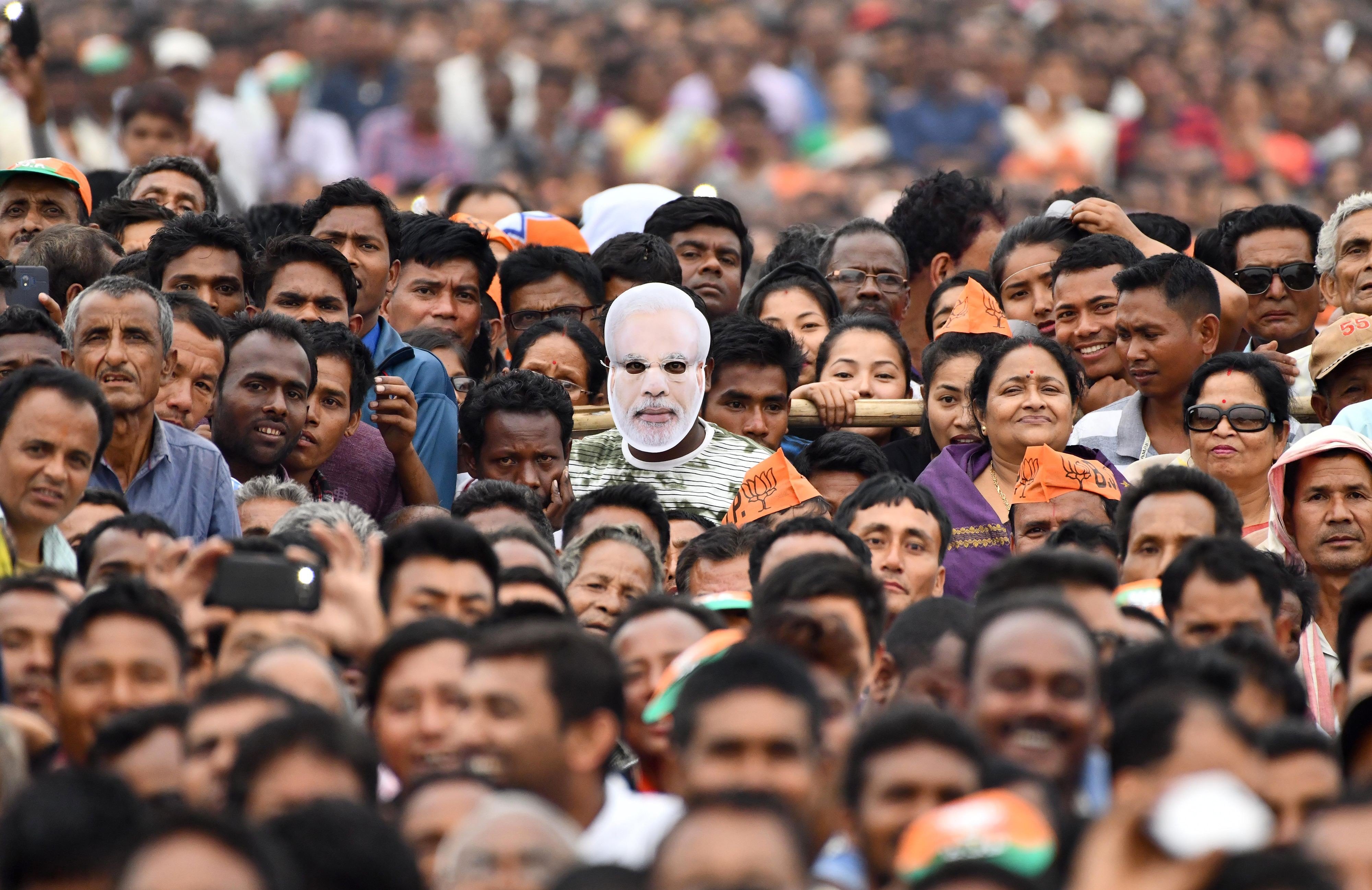 An Indian supporter of the Bharatiya Janata Party (BJP) wearing a mask of Prime Minister Narendra Modi and other supporters attend one of Modi's political campaigns ahead of India's general election in Gohpur, the capital city of the northeastern state of Assam, on March 30. Photo: AFP