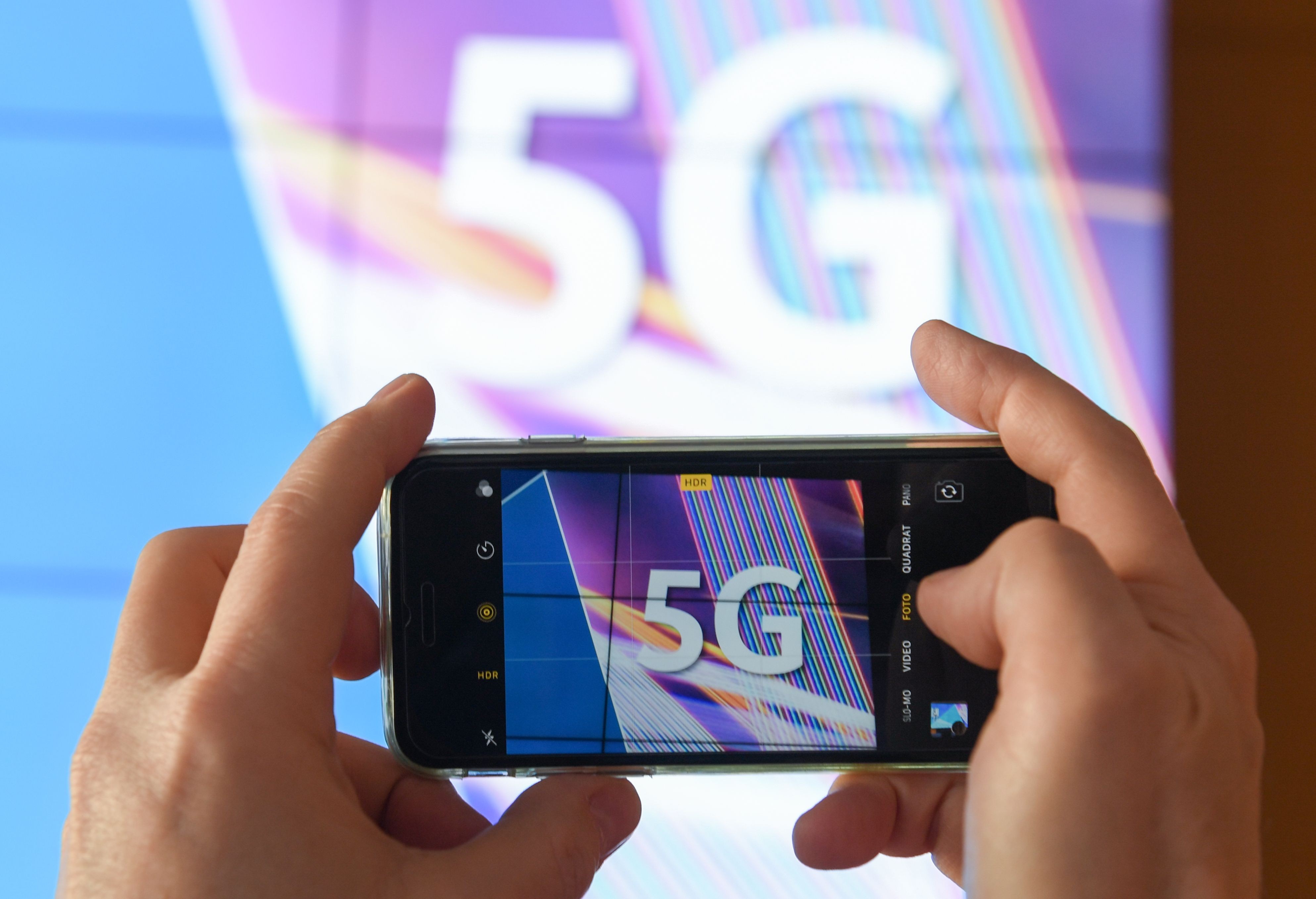A journalist takes pictures of a projection screen prior to the start of Germany’s auction for the construction of an ultra-fast 5G mobile network last month. Photo: AFP