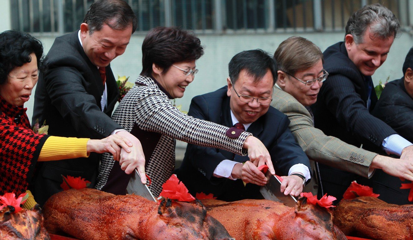 Dignitaries, including then Secretary for Development Carrie Lam (third from left), cut into roast suckling pigs at the opening ceremony of the Hong Kong West Drainage Tunnel Project in February 2011. Photo: Jonathan Wong